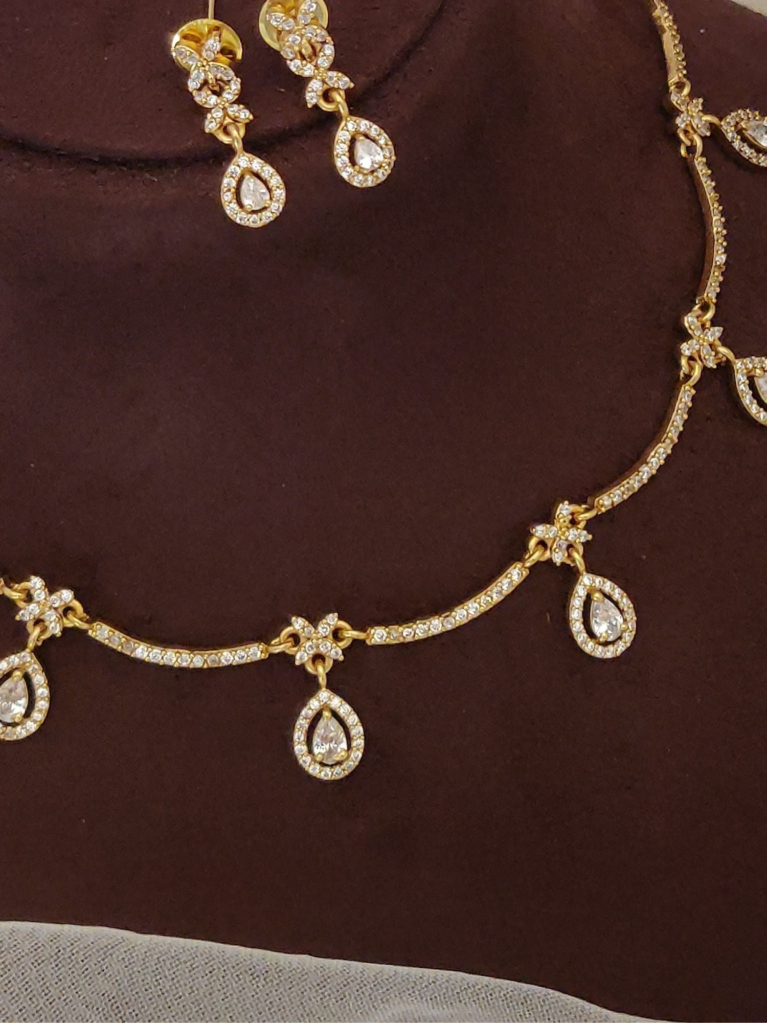 Abdesignsjewellery gold teardrop set on brown bust showing artificial diamond necklace with earrings for bridal wear