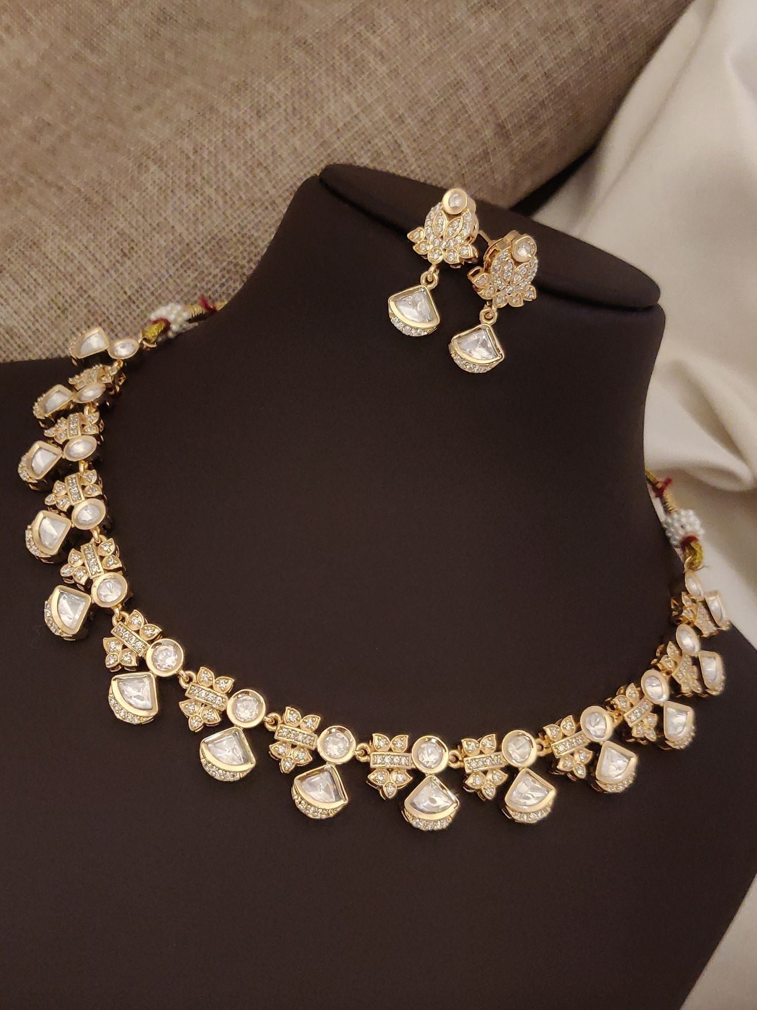 Elegant artificial polki necklace with earrings, featuring intricate gold design and shiny gems