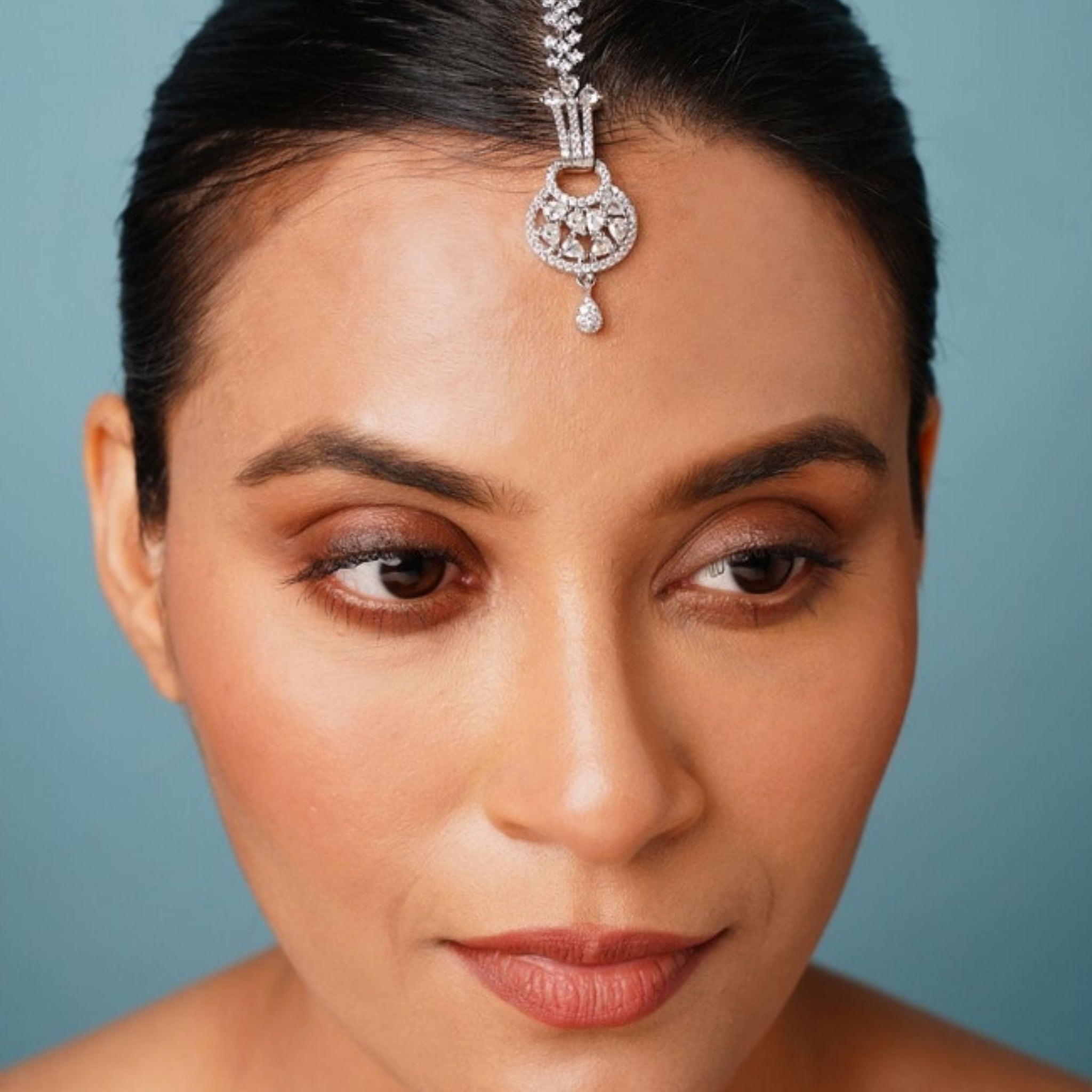 Beautiful Silver Plated American Diamond Maangtikka worn on forehead by woman with sleek hair