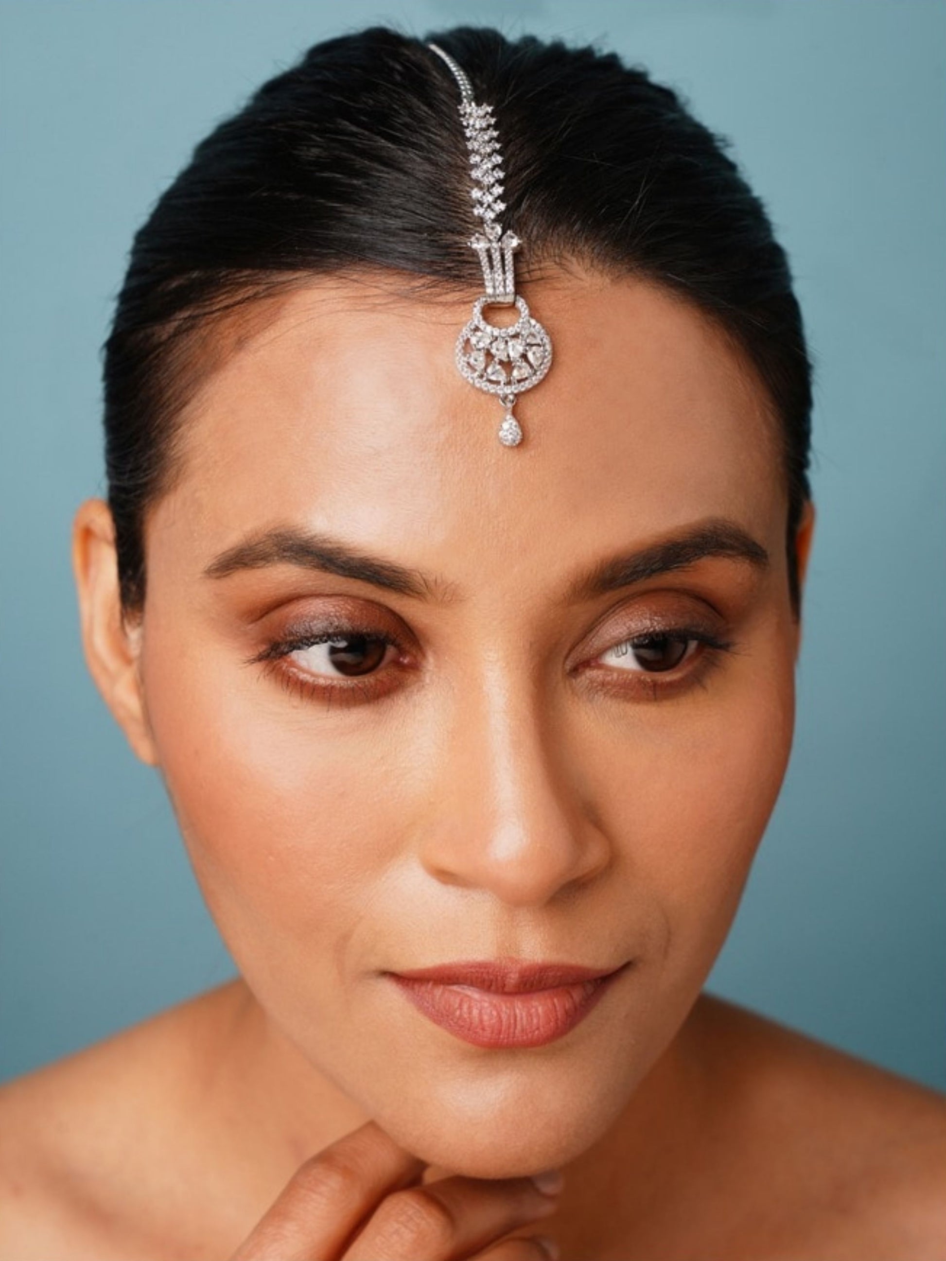 Beautiful Silver Plated American Diamond Maangtikka worn on forehead by woman with sleek hair