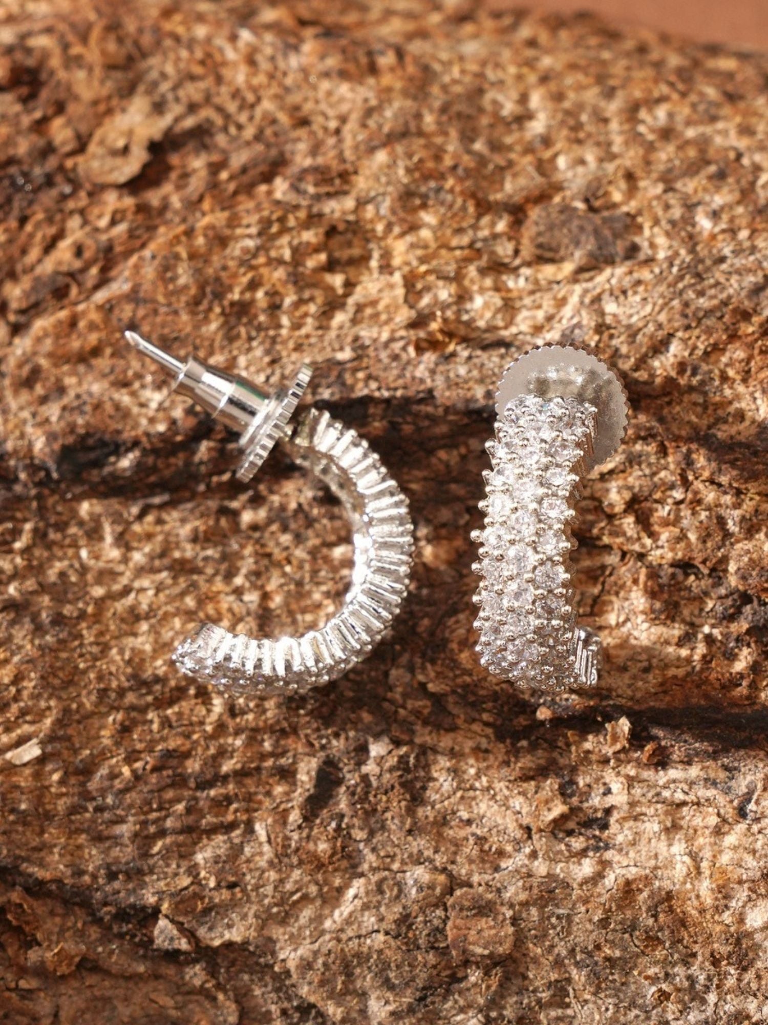 Delicate Silver Plated American Diamond Earring by Abdesignsjewellery displayed on textured brown surface