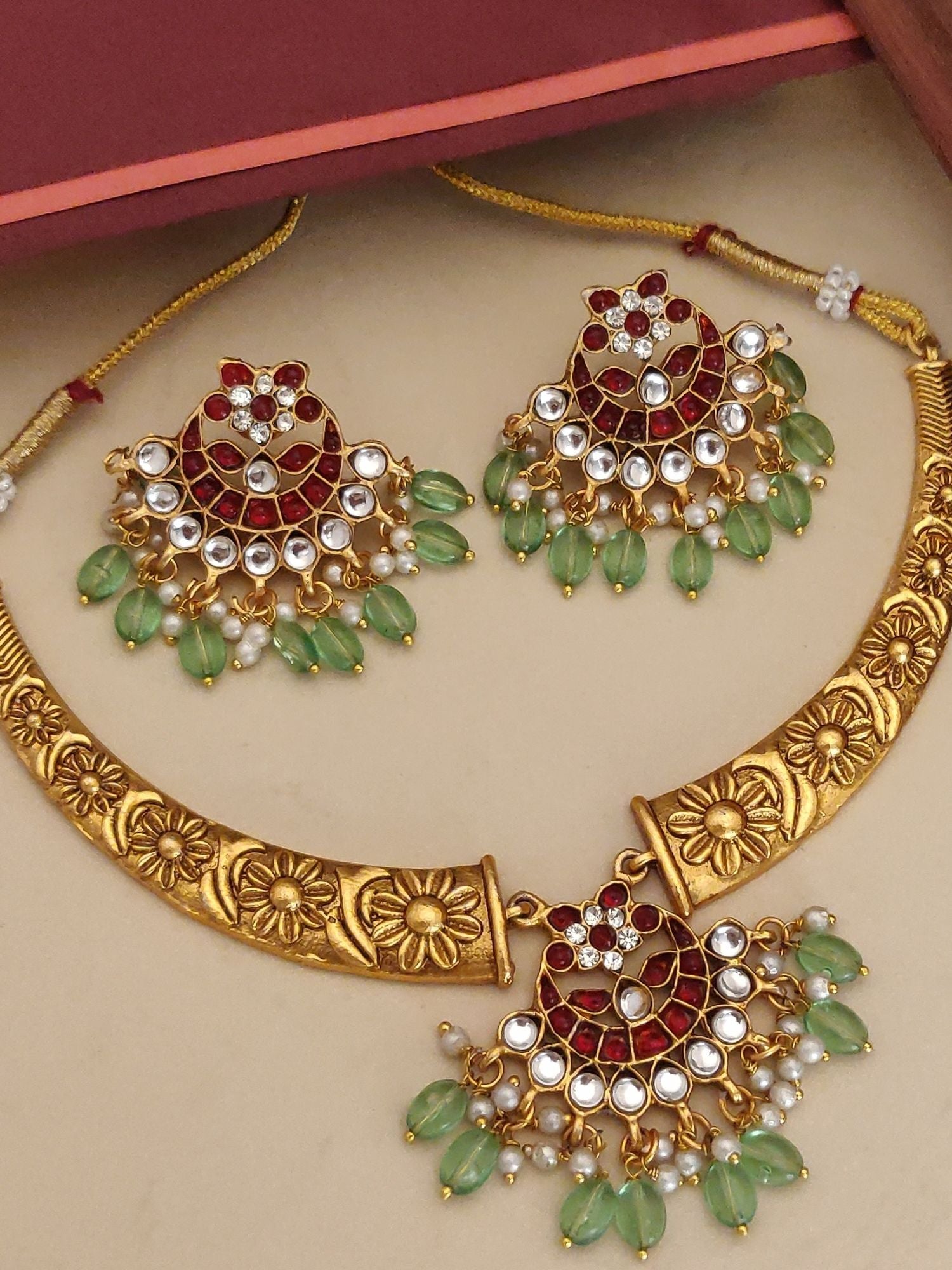 Gold floral necklace and matching earrings with red stones and green teardrop beads designer fashion necklace set for women