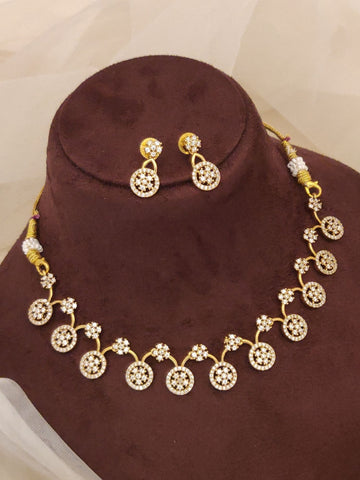 Designer gold plated fashion jewelry india gold necklace with circular stone motifs and matching earrings displayed on brown bust