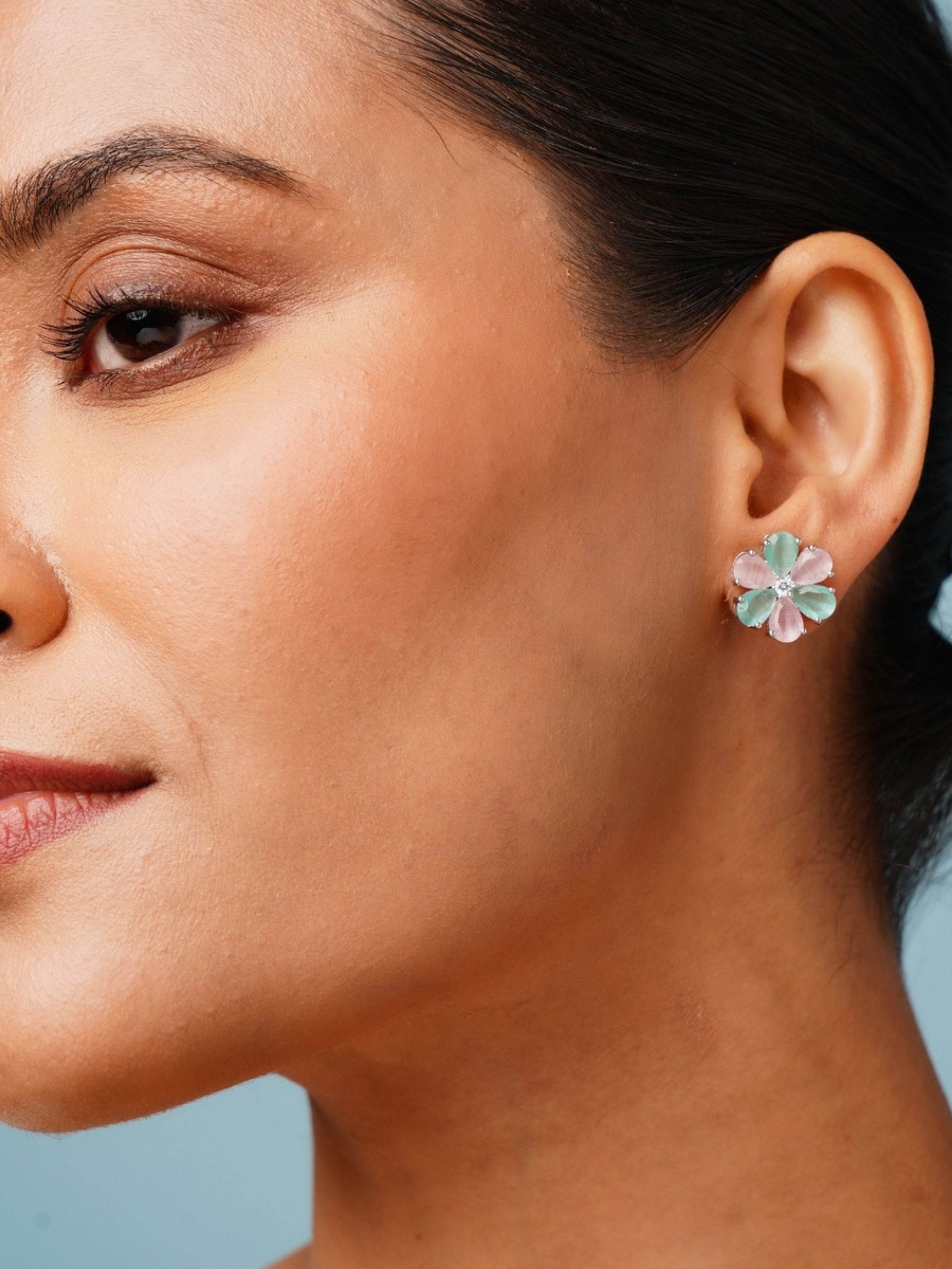 Close up of woman wearing Elegant Green Stone Earrings By Abdesigns Jewellery. Floral green stone petal stud earrings