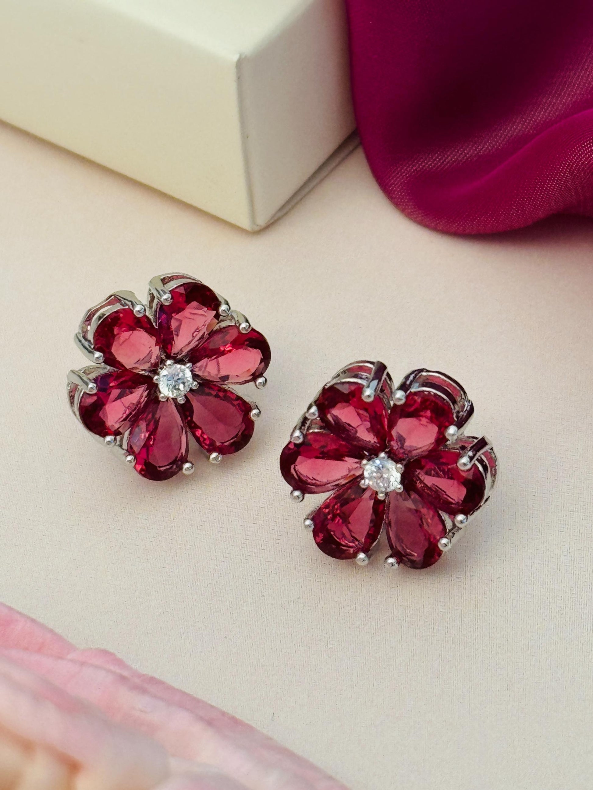 Red flower crystal stud earrings with silver prongs on display Elegant Green Stone Earrings By Abdesigns Jewellery.