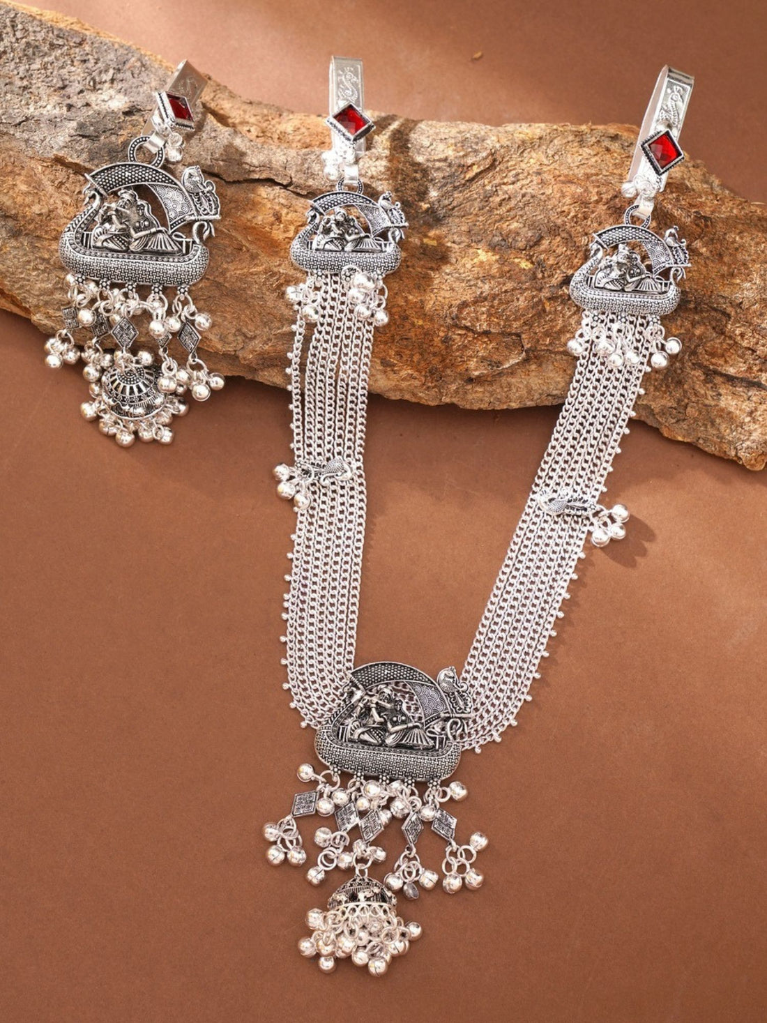 German silver saree juda pin combo with intricate peacock motifs and dangling jhumki tassels on red saree