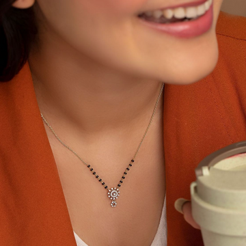 Gold Plated American Diamond Mangalsutra with black beads worn by woman in orange outfit
