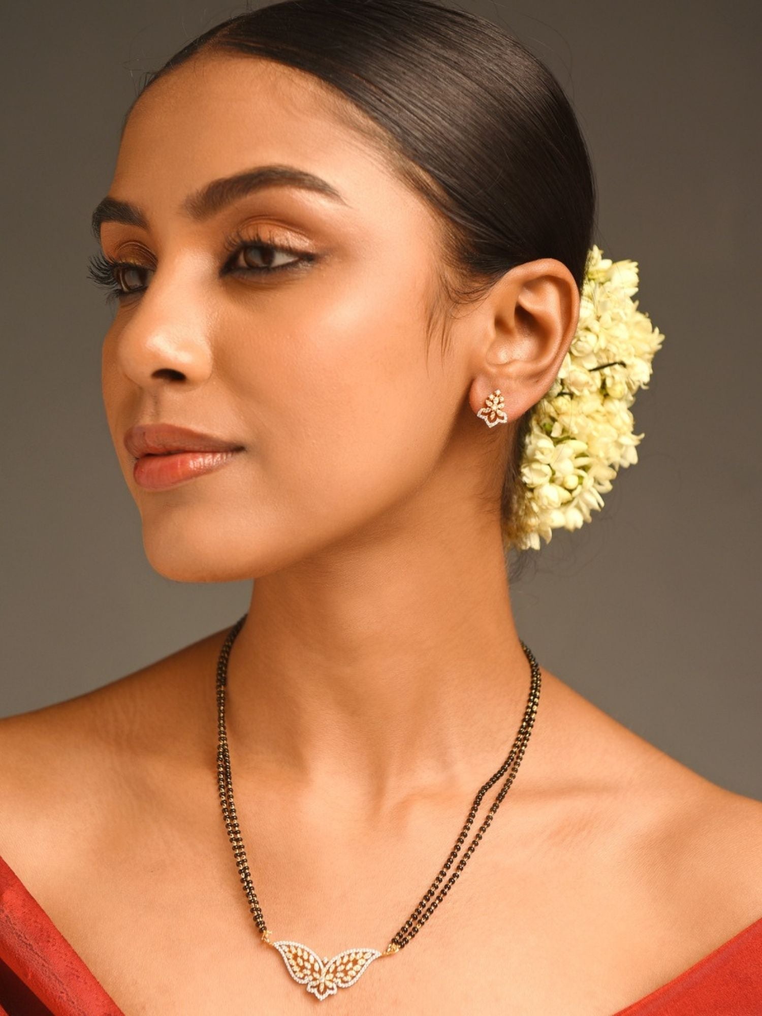 gold plated American diamond mangalsutra set worn by model with butterfly pendant double black bead chains and jasmine hair gajra