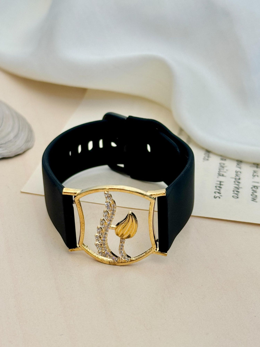 Abdesignsjewellery gold plated hand belt bracelet with gold leaf and crystal accents on black leather strap on wrist