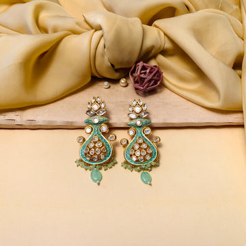 gold plated kundan meenakari earrings with green enamel and teardrop beads on satin cloth