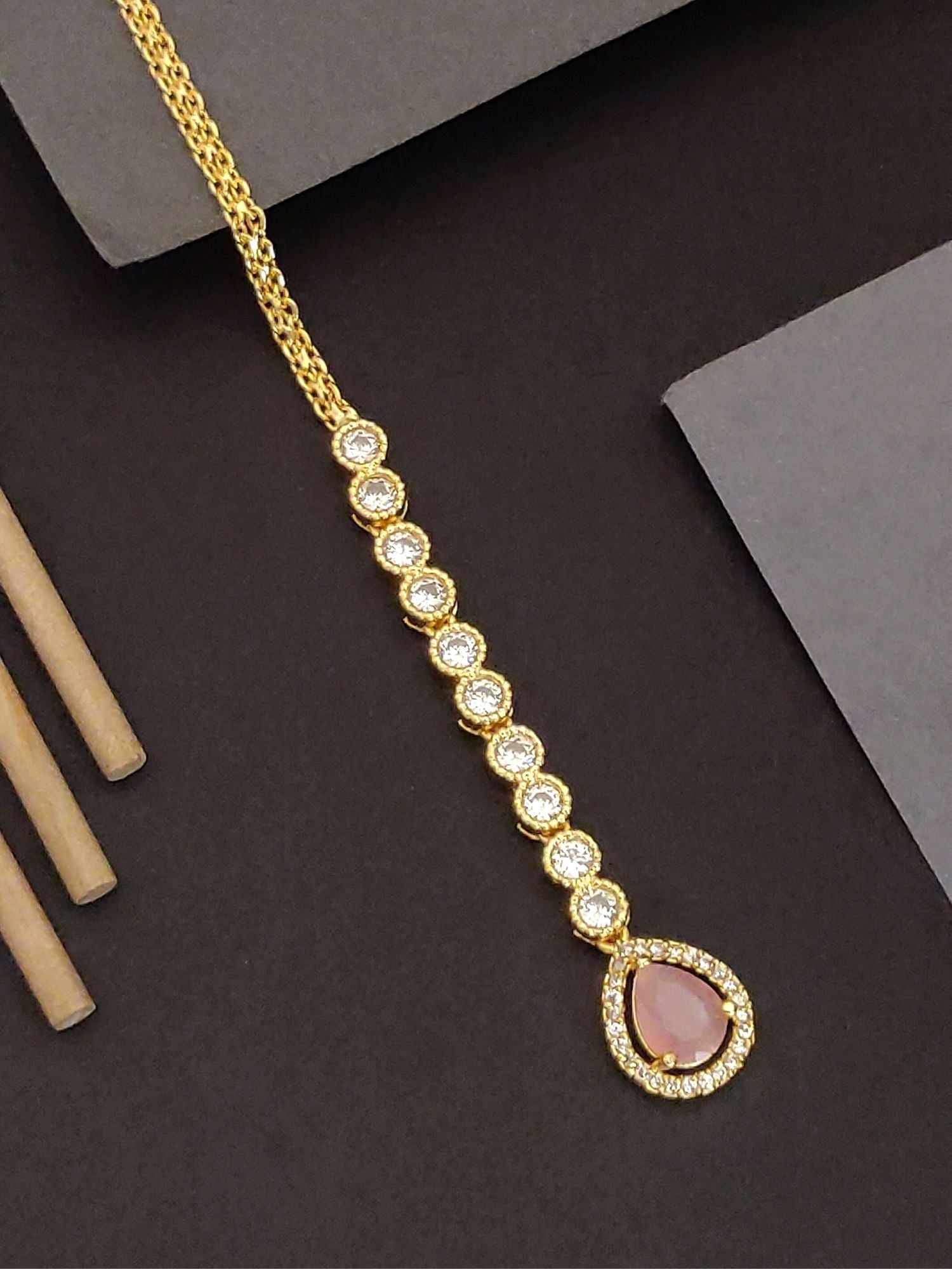 Elegant gold-plated maangtikka with a sleek design and sparkling gemstones for traditional occasions