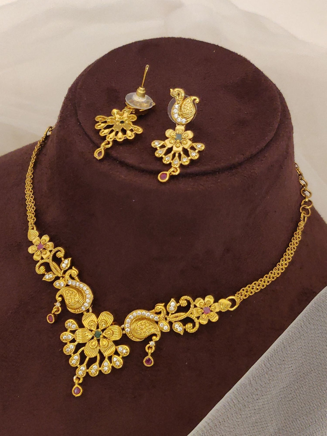 Abdesignsjewellery Gold Plated Peacock Necklace Set with floral motifs and matching earrings on display
