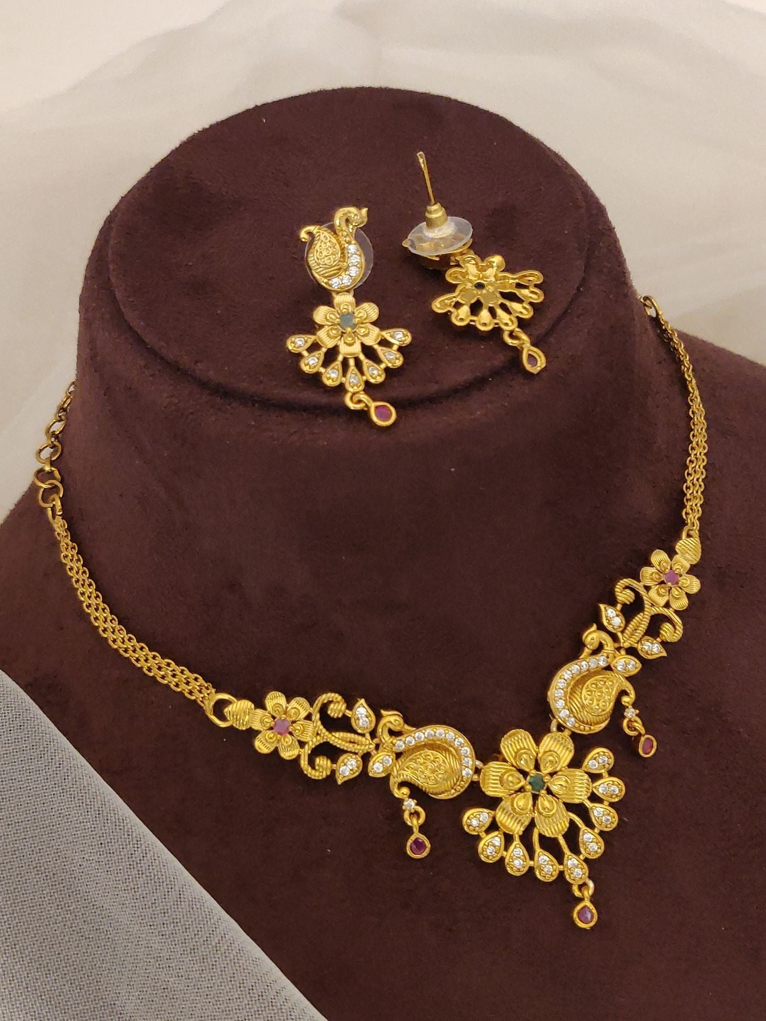 Abdesignsjewellery Gold Plated Peacock Necklace Set with floral motifs and matching earrings on display