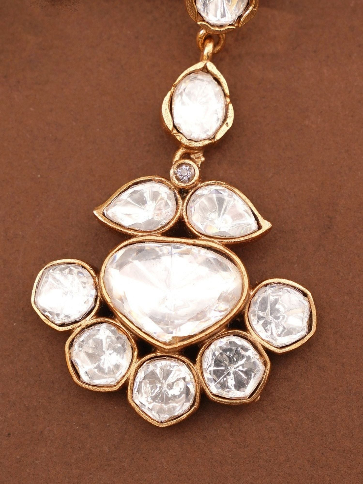 Abdesignsjewellery gold plated polki maangtikka close up showing heart and teardrop polki stones on brown background