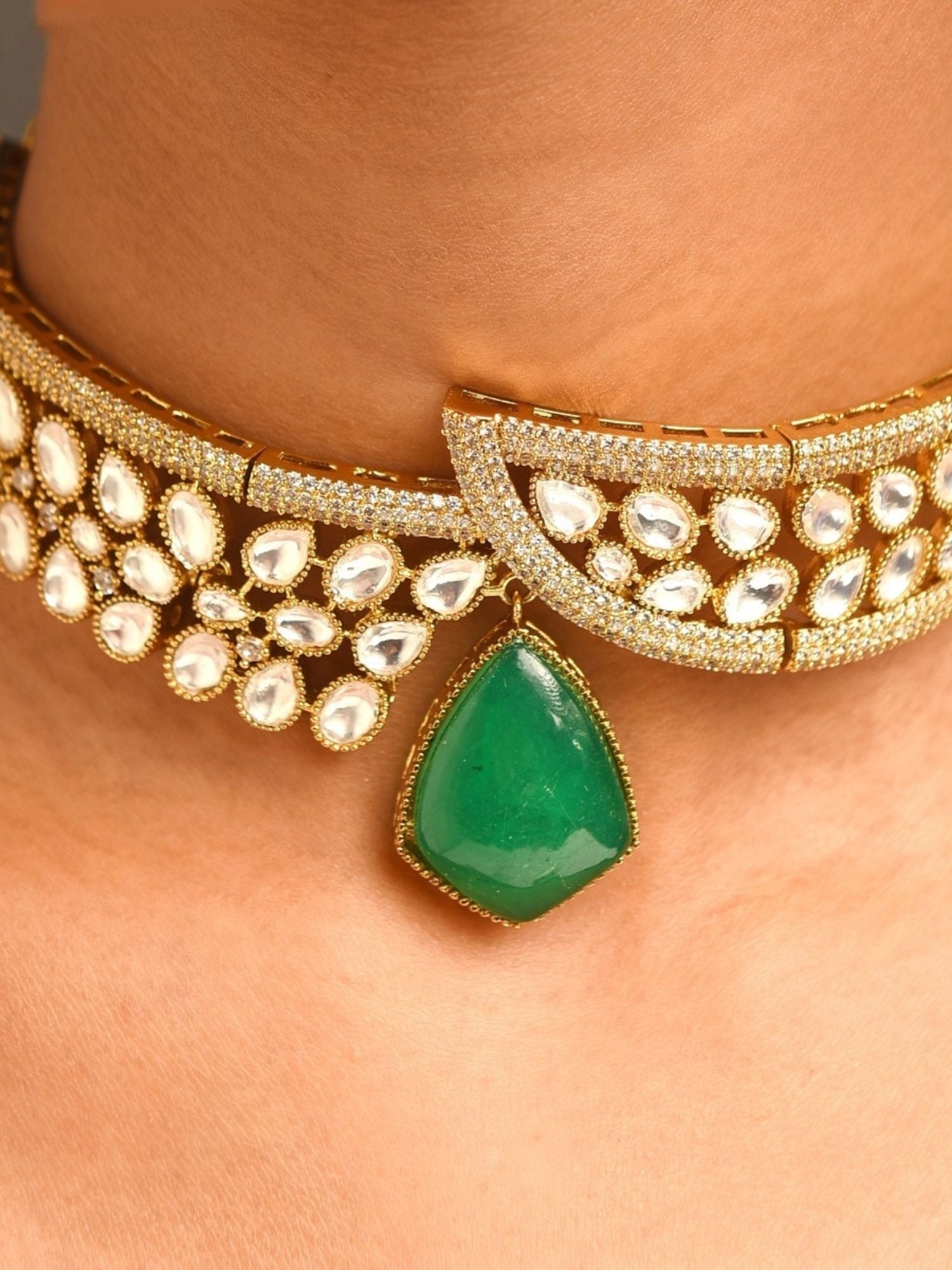 gold plated polki necklace set choker with pear shaped polki stones and green teardrop pendant on model neck