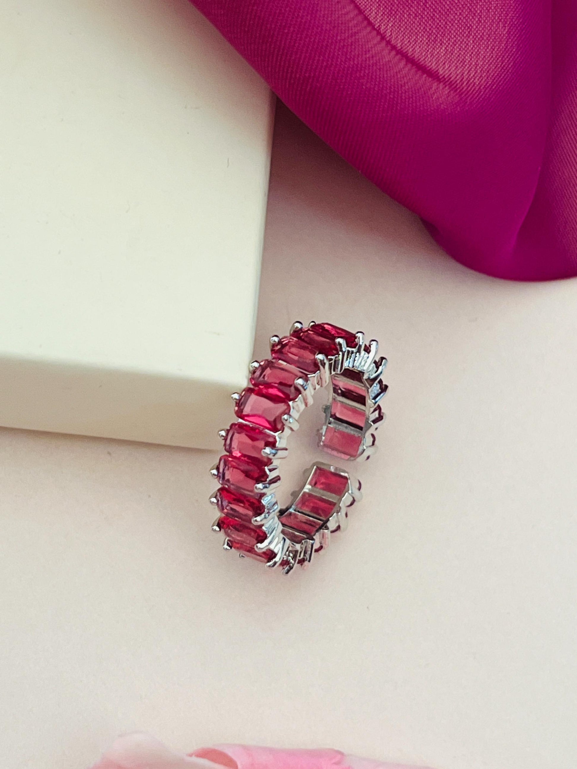 Silver ring with red stones displayed on light background by Abdesignsjewellery