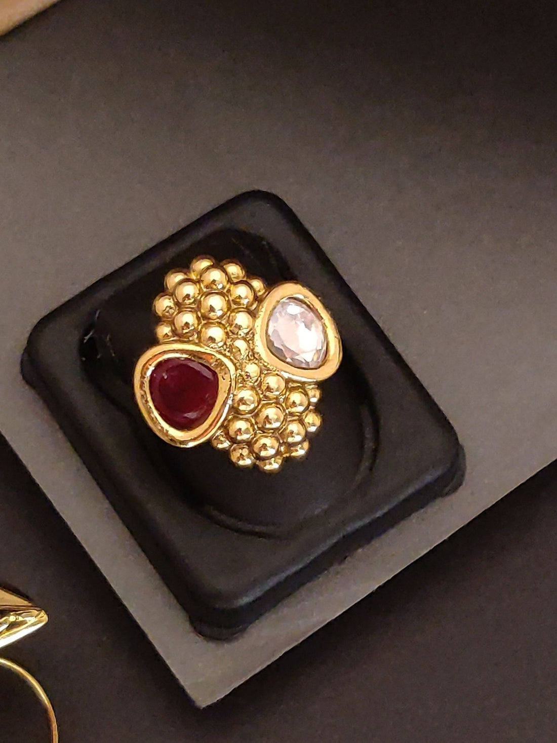 Abdesigns Jewellery Gold Plated Beaded Ring with Gemstones featuring red and white stones on a black display