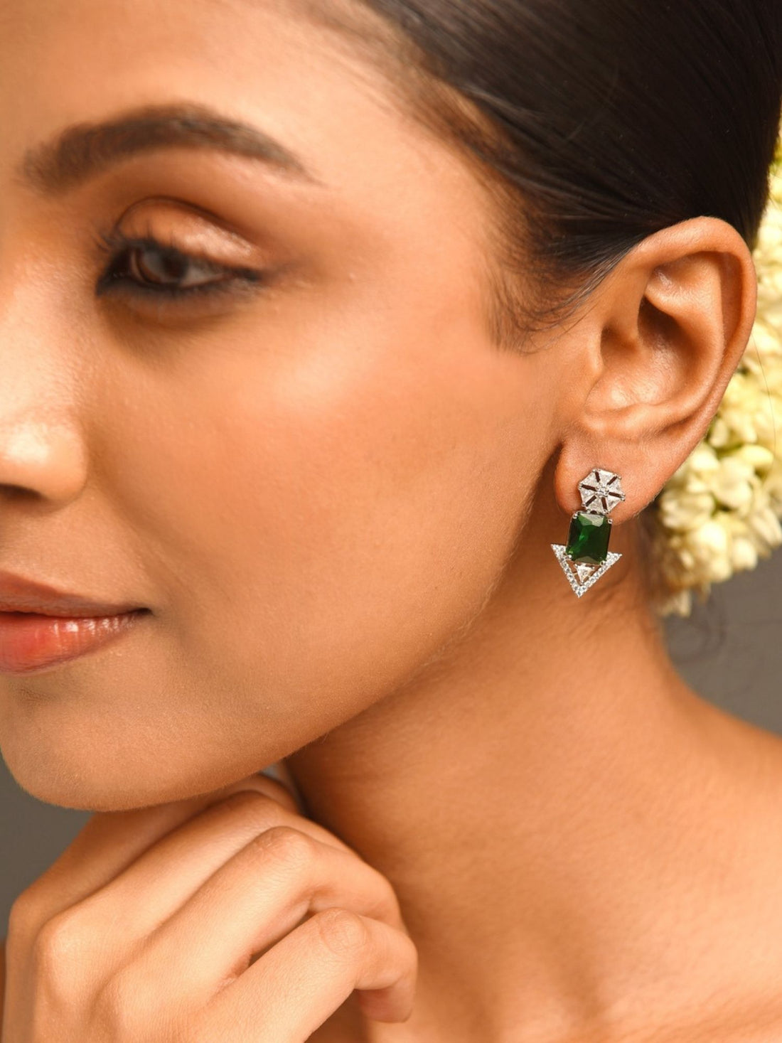 Close-up of woman wearing Abdesigns Jewellery Green Stone Arrow Earrings with silver and green stones