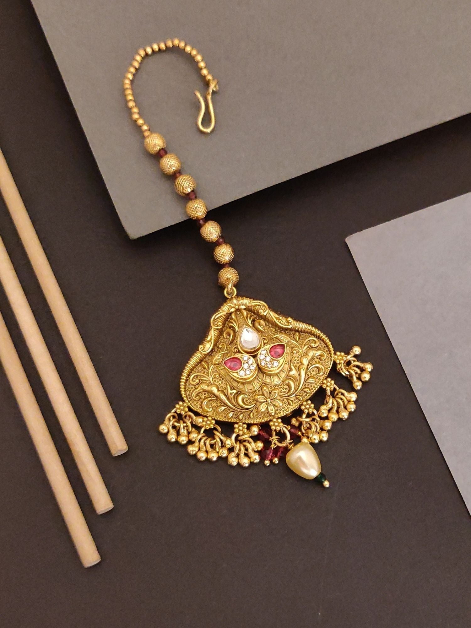Abdesigns Jewellery Maangtikka elegant gold-tone design with intricate floral patterns and pearl accents