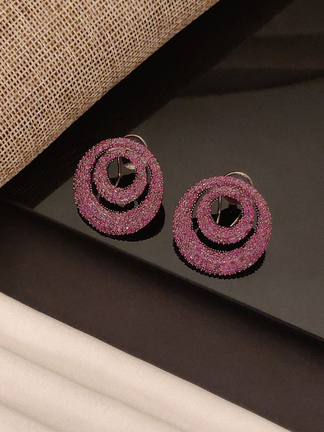 Abdesigns Jewellery Pink Crystal Circle Drop Earrings sparkling with two concentric pink crystal circles on black surface
