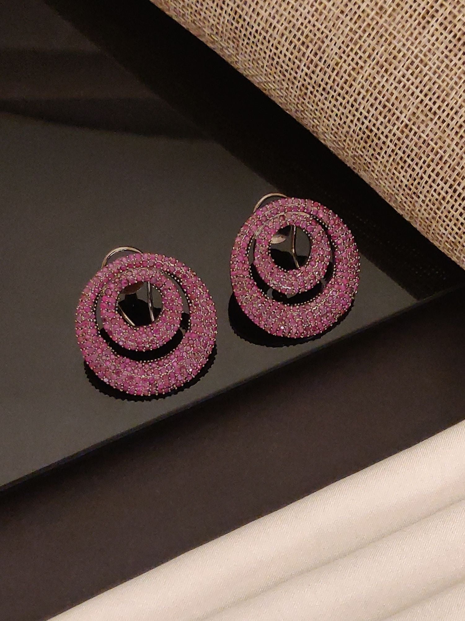 Abdesigns Jewellery Pink Crystal Circle Drop Earrings sparkling with two concentric pink crystal circles on black surface