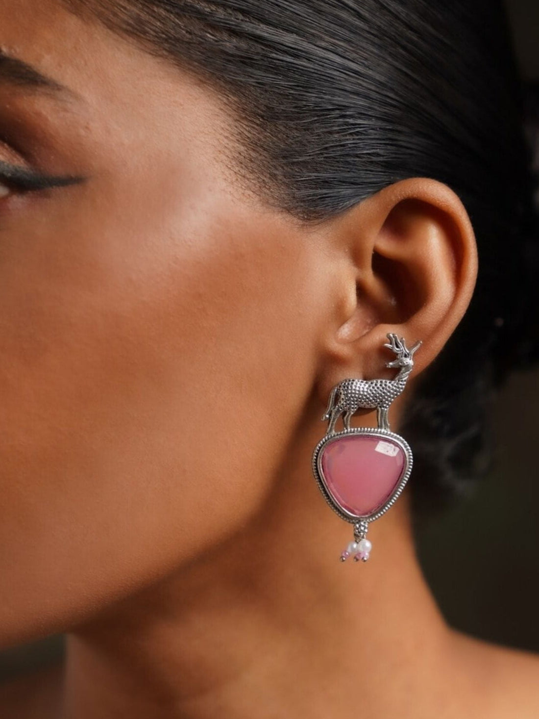 Abdesigns Jewellery Silver Deer Green Stone Earrings worn on woman's ear with detailed deer design