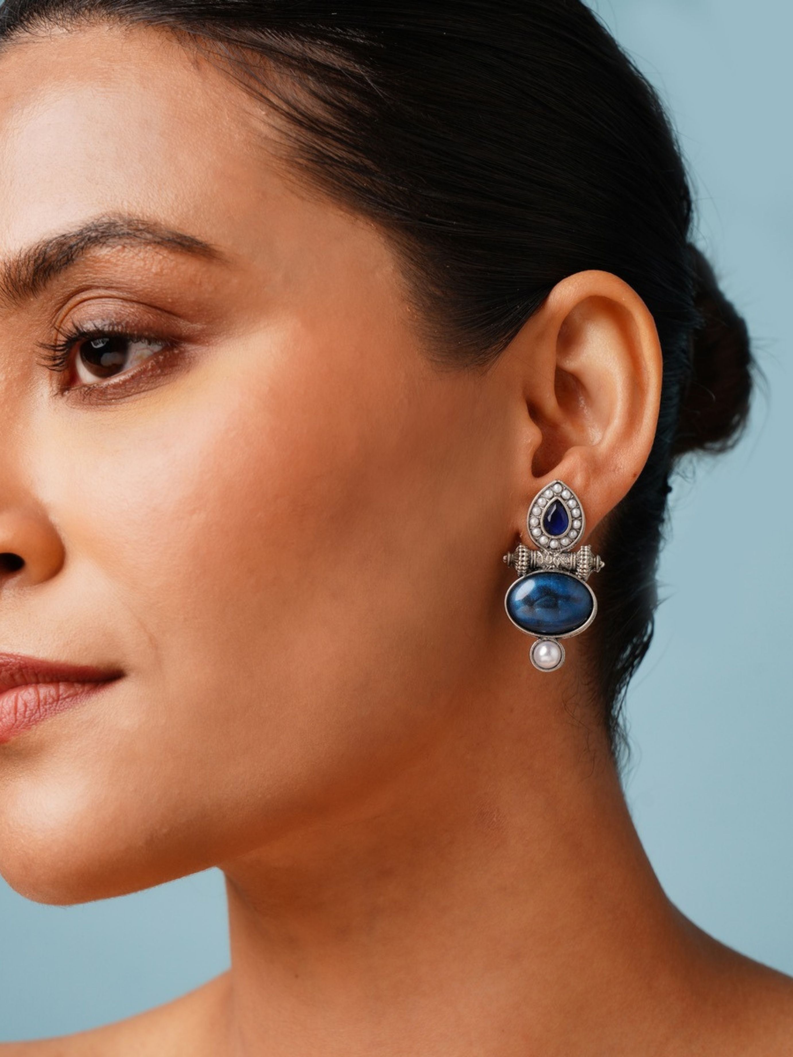Abdesigns Jewellery Silver Plated Blue Stone Pearl Earrings worn by woman with blue background