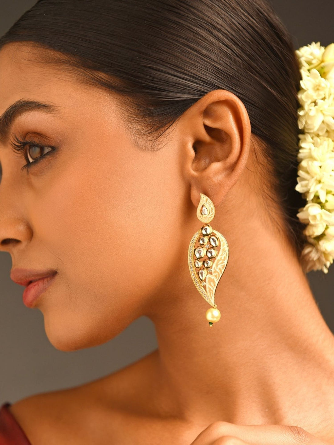 Woman wearing Abdesigns Jewellery Simple Gold Plated Kundan Earrings with intricate leaf design and pearl drop