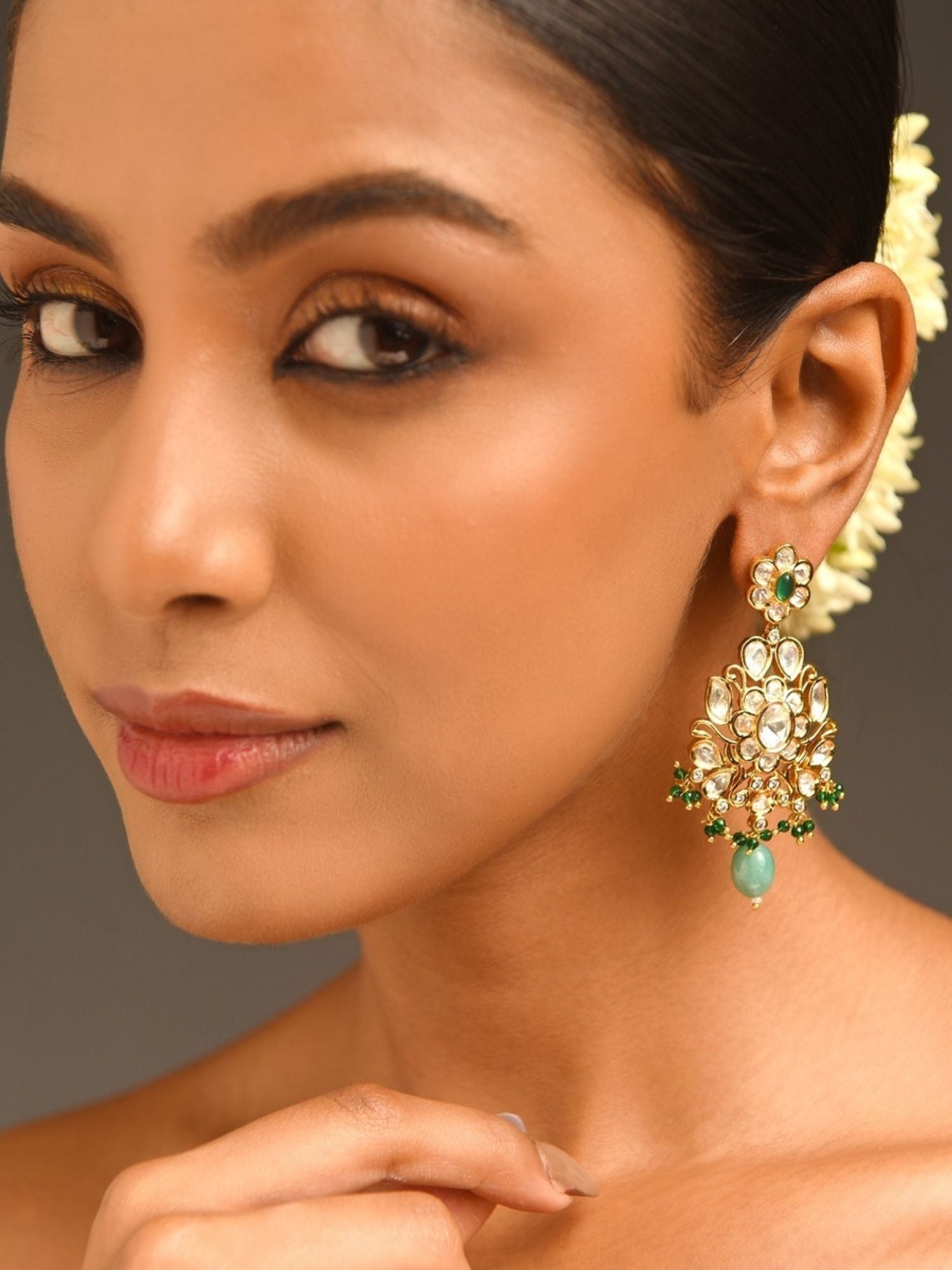 Woman wearing Majestic Gold Plated Kundan Polki Earrings with green and white stones by Abdesignsjewellery