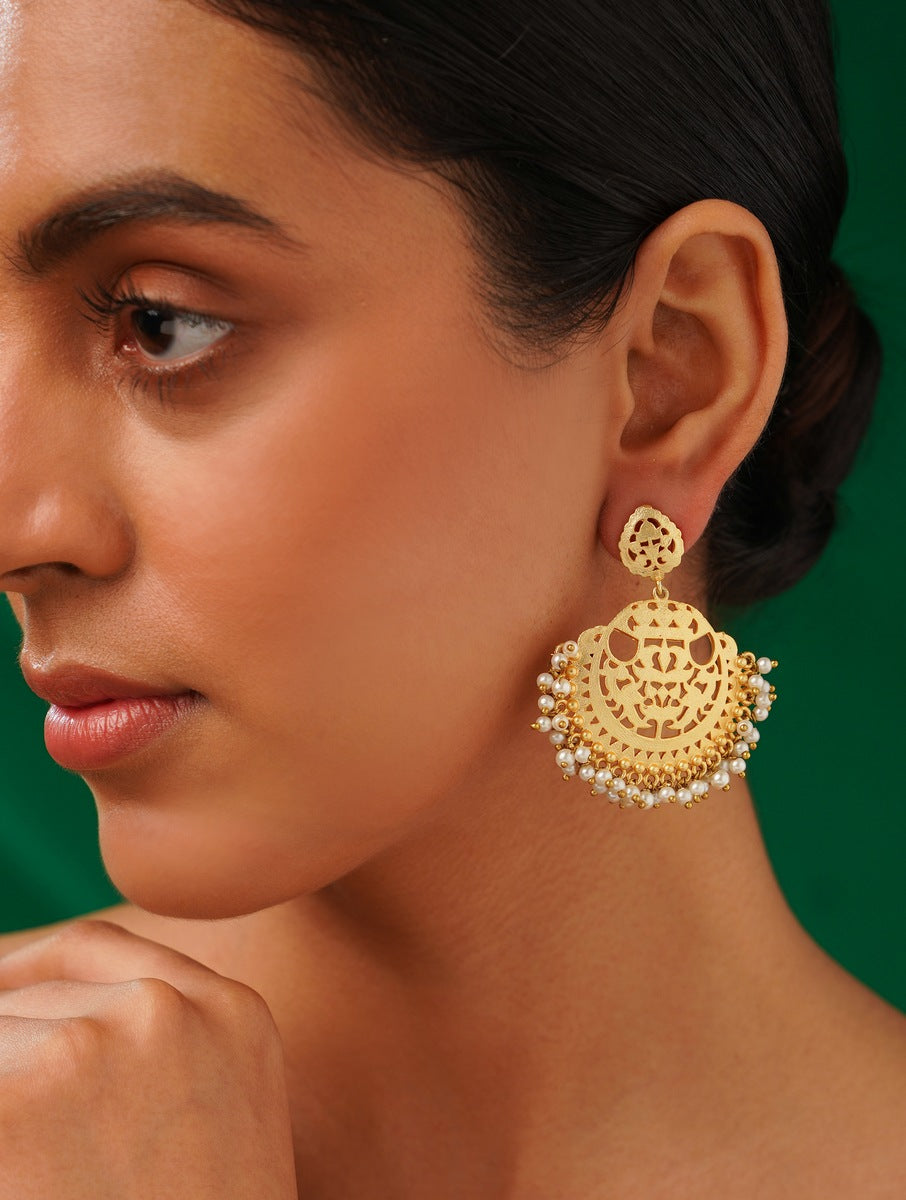 Matt Gold Plated Baroque Pearl Earrings by Abdesignsjewellery worn by a woman with green background