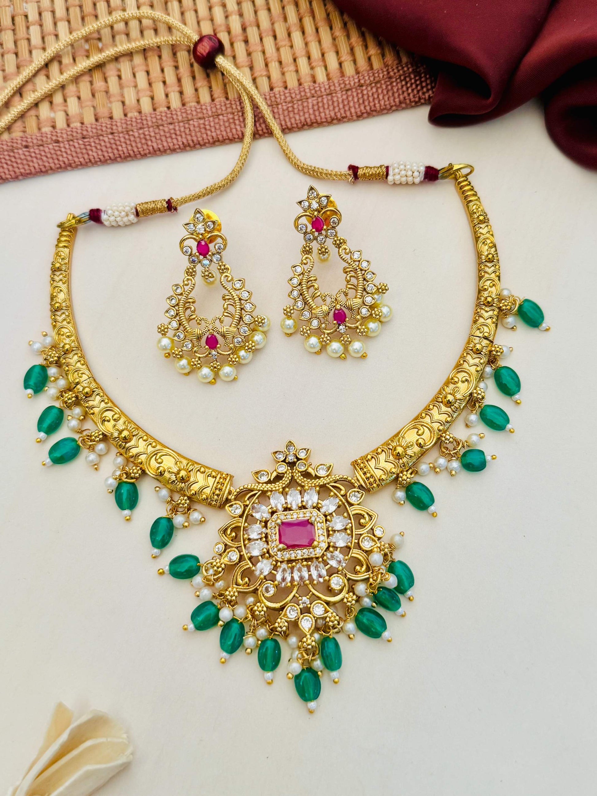 Matt Gold Plated Temple Necklace Set with intricate green and white stone embellishments and matching earrings