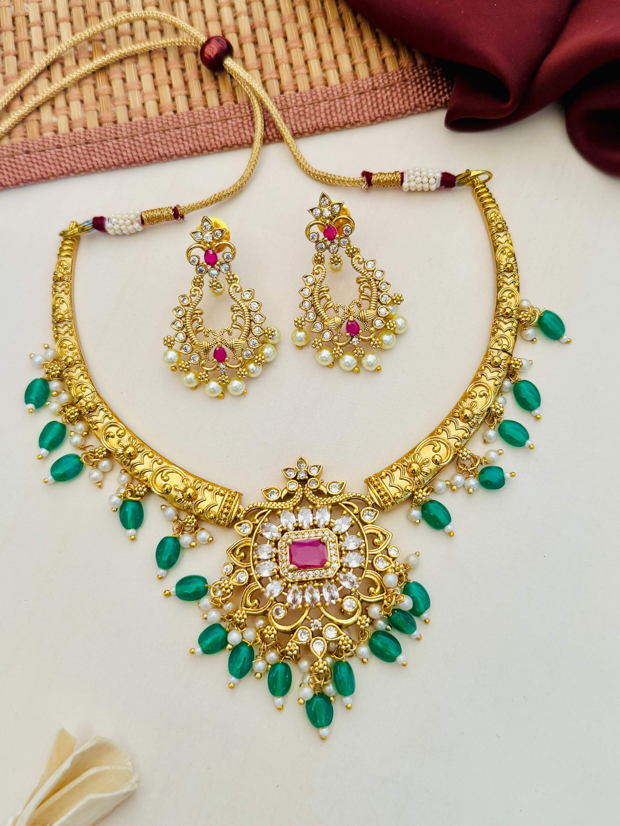 Matt Gold Plated Temple Necklace Set with intricate green and white stone embellishments and matching earrings