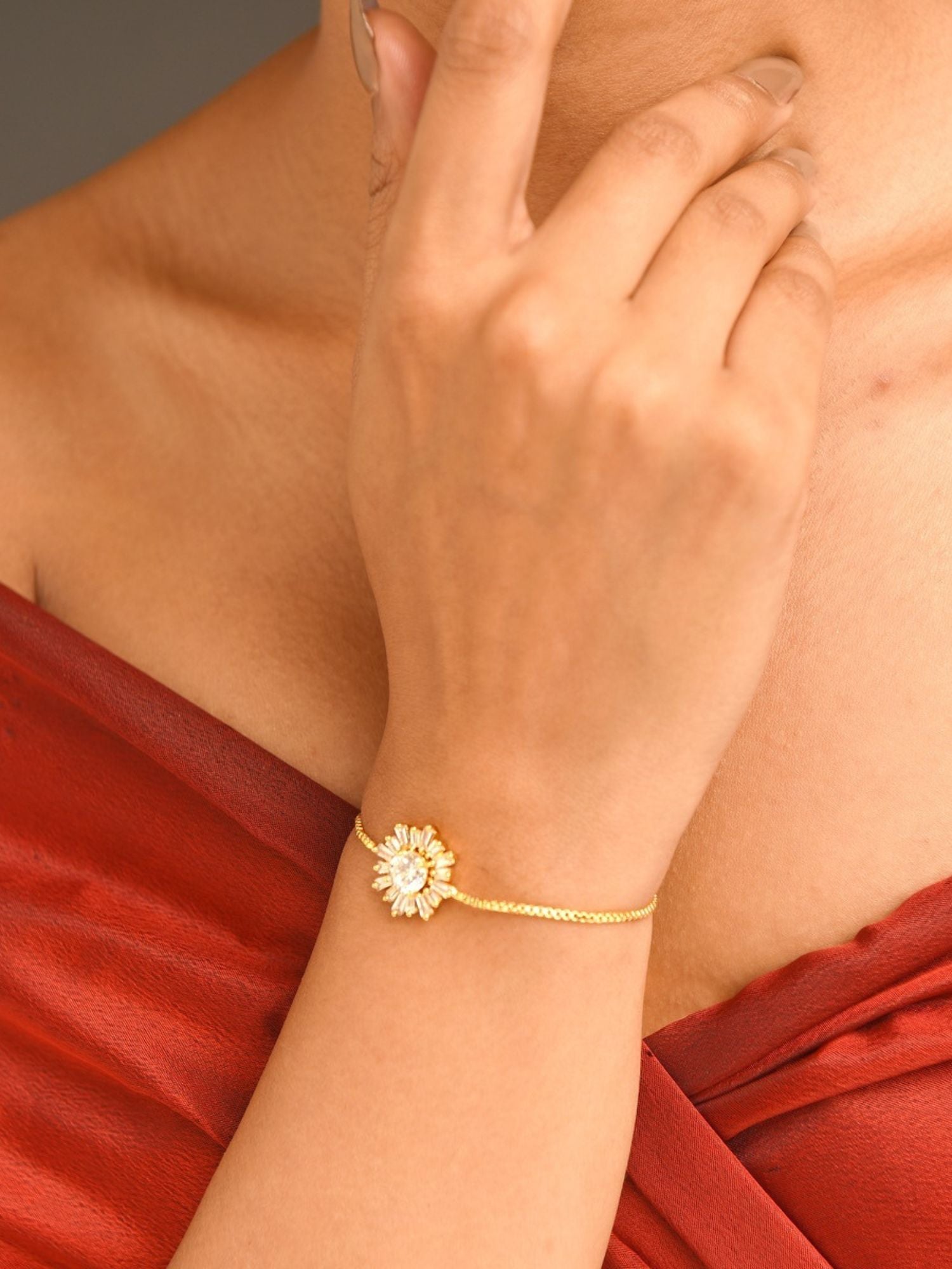Abdesignsjewellery minimal gold plated bracelet with floral charm on model wrist styled with red dress