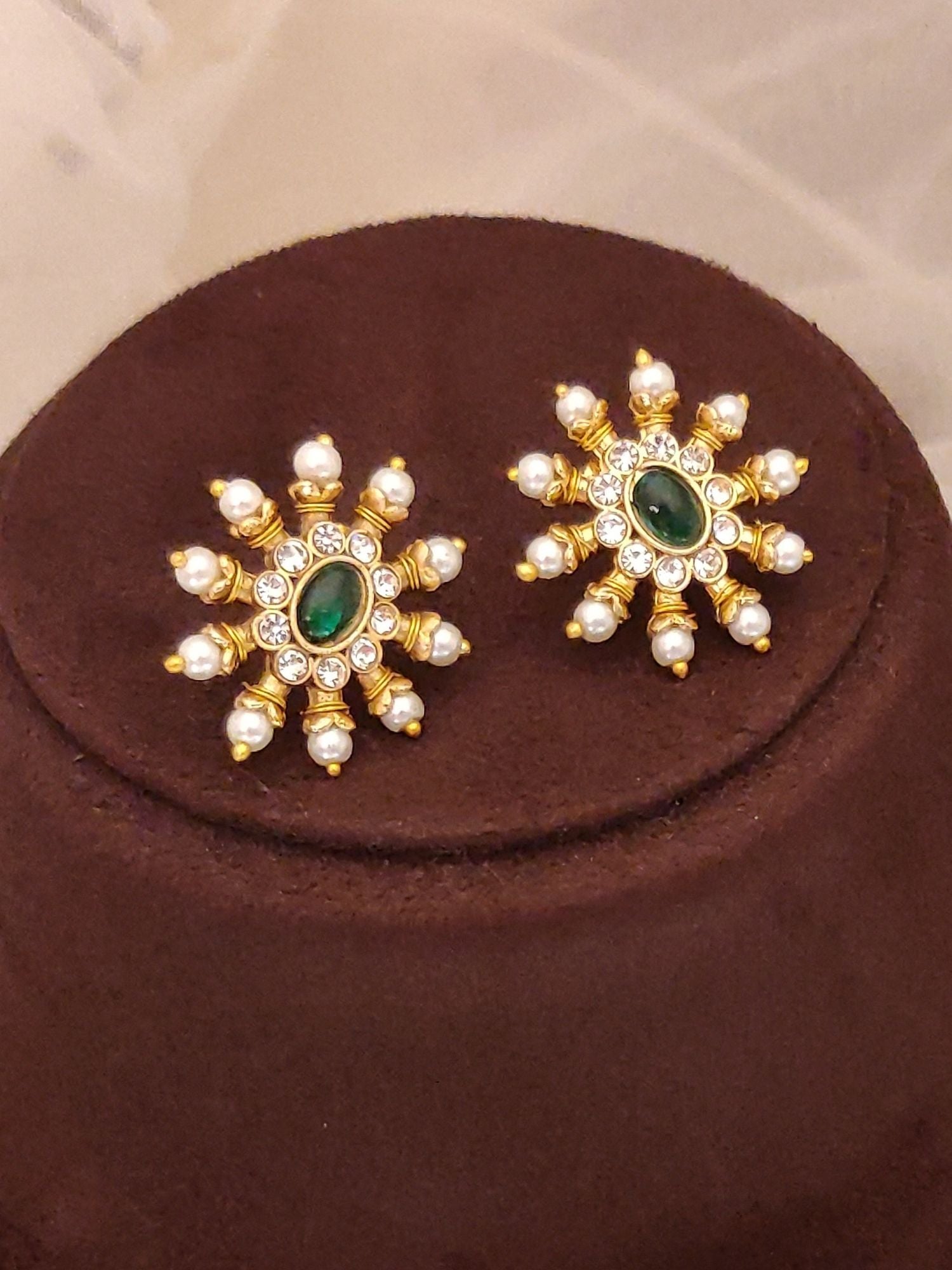 Abdesignsjewellery pearl and green stone pendant set pair of gold floral pendants with pearl accents on brown display