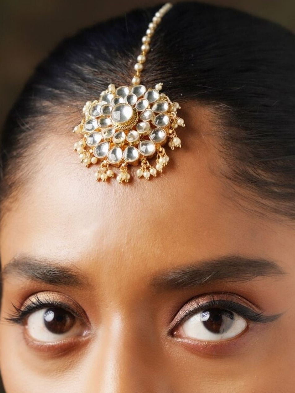 Close-up of Polki Kundan Maangtikka worn on forehead showcasing intricate gold and white stone design by Abdesignsjewellery