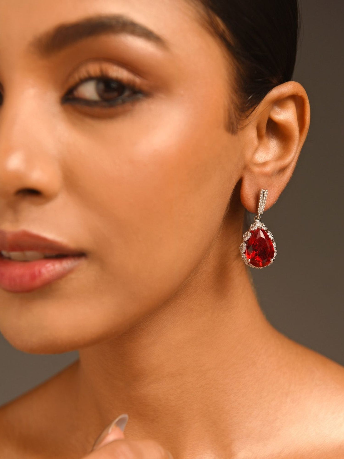Abdesignsjewellery red drop earrings for women pear shaped red gemstone teardrop with crystal halo in silver worn on model