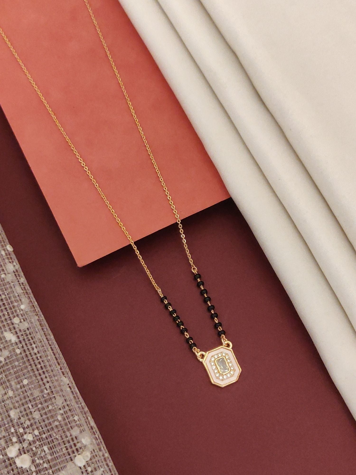 Abdesigns Rose Gold Plated Black Beads Mangalsutra with Elegant Design on Textured Background