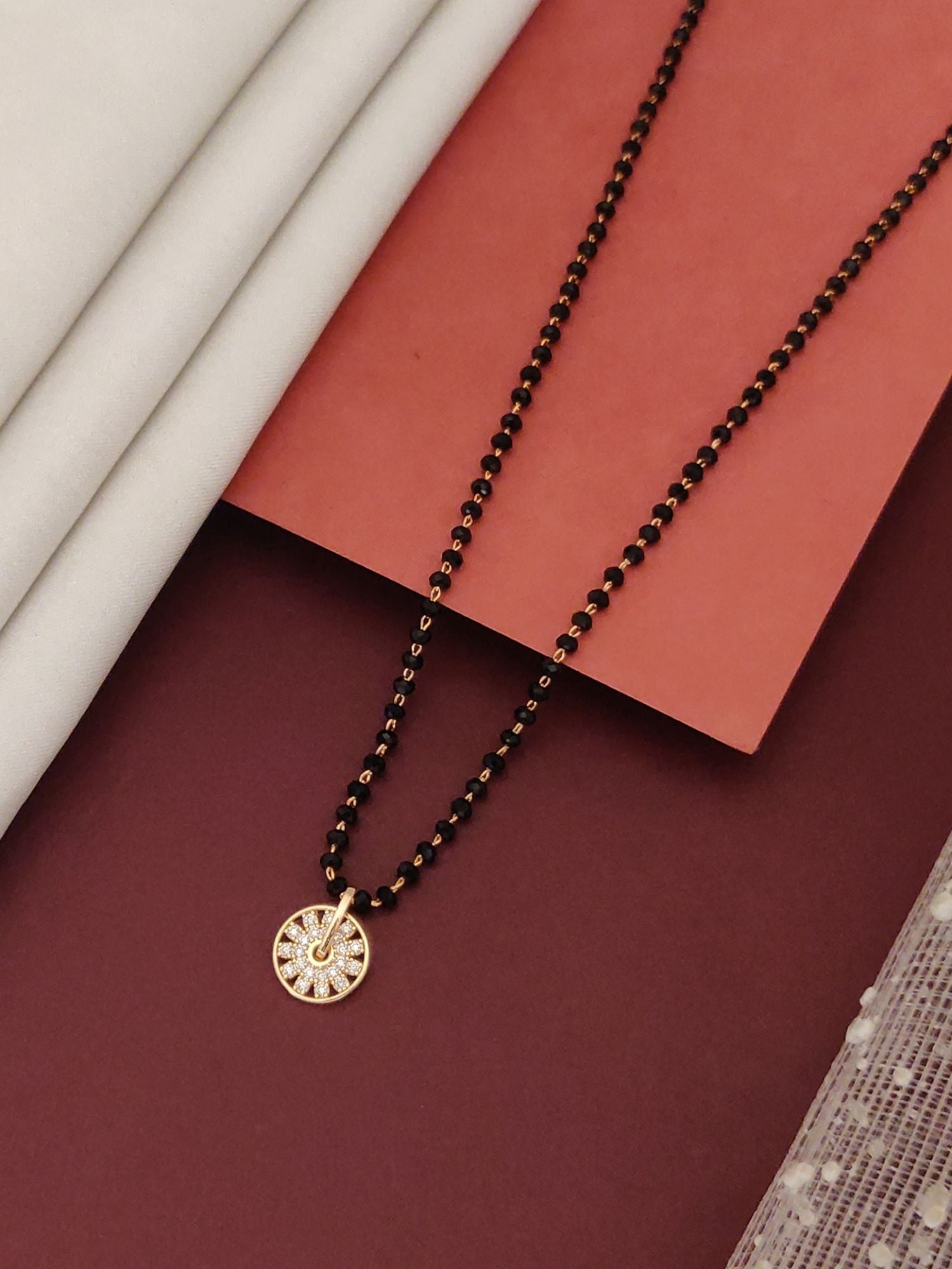 rose gold plated mangalsutra for women with black beaded chain and round disc pendant with crystal accents