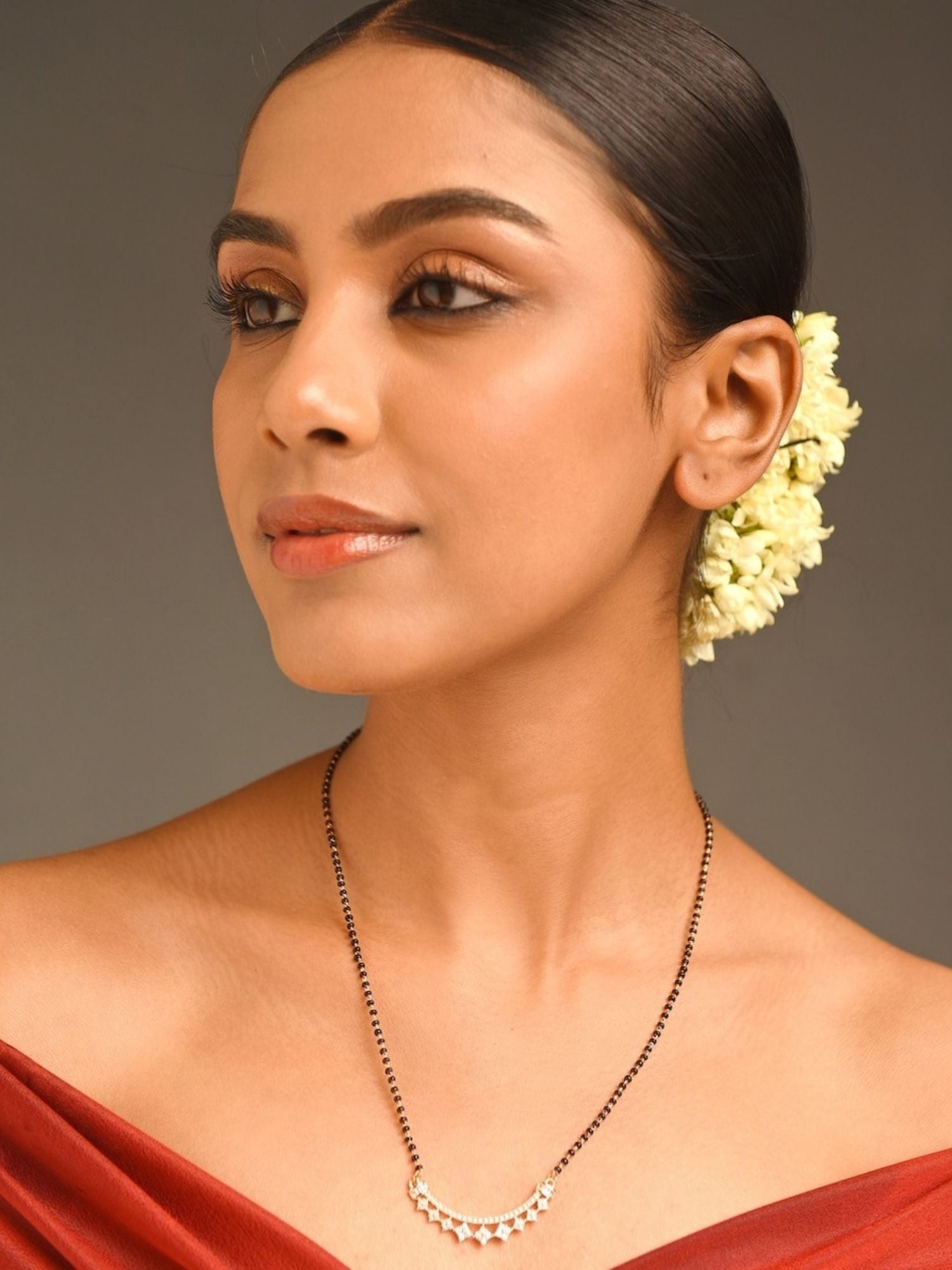 Abdesignsjewellery model wearing rose gold plated mangalsutra with black bead chain and floral hair gajra