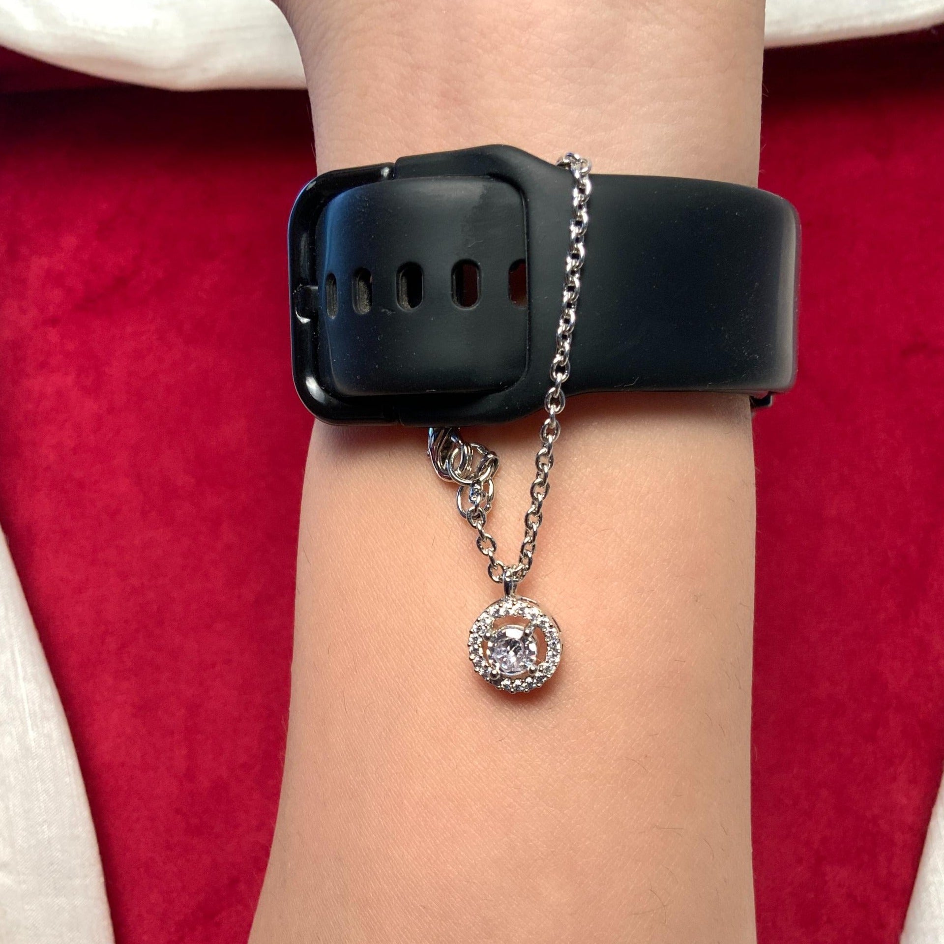 Round Shape AD Silver Plated Watch Charm bracelet worn on wrist with black watch strap background