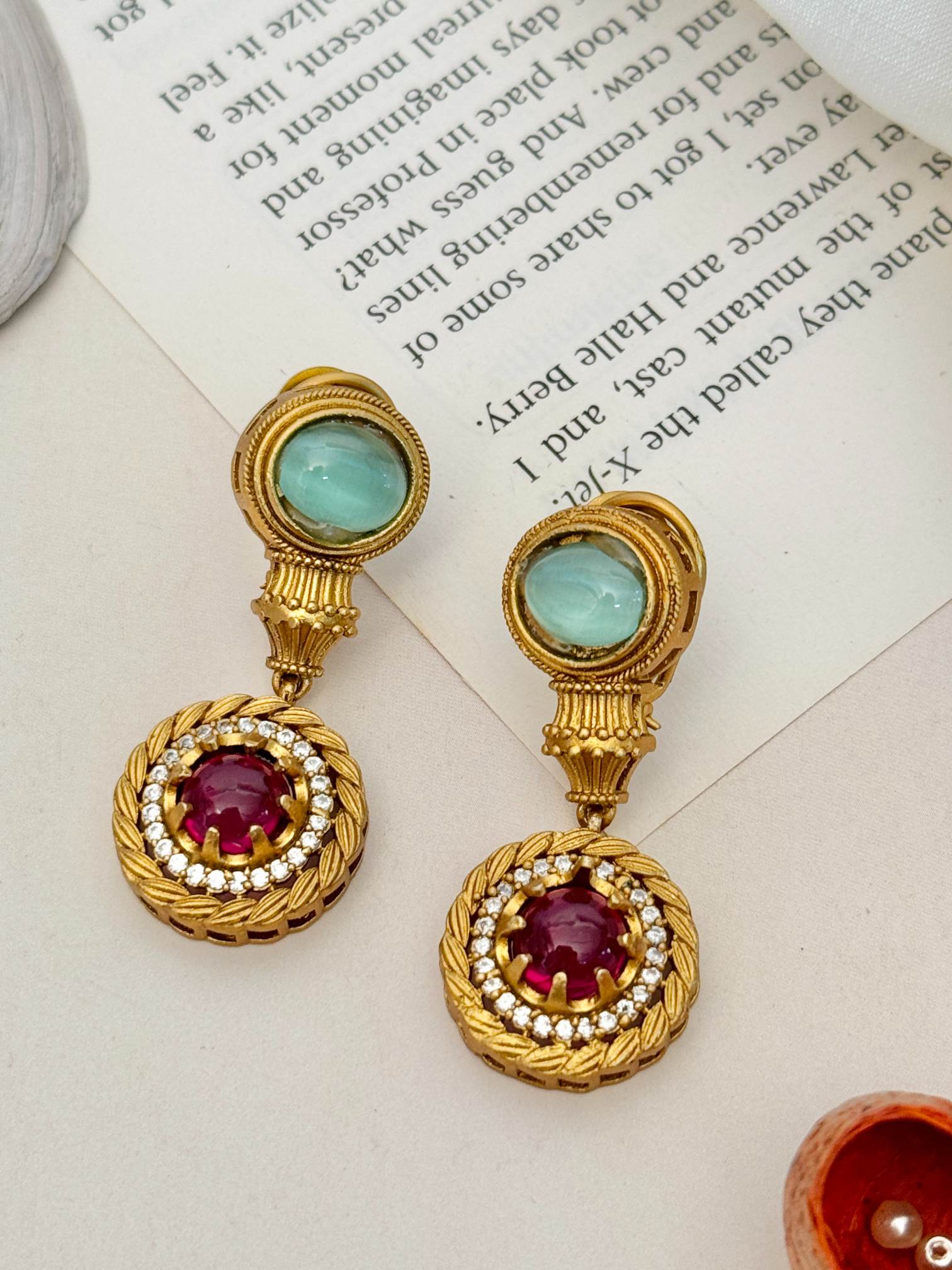 Gold drop earrings with green cabochons and ruby centers surrounded by diamonds to match Sabyasachi inspired diamond necklace set