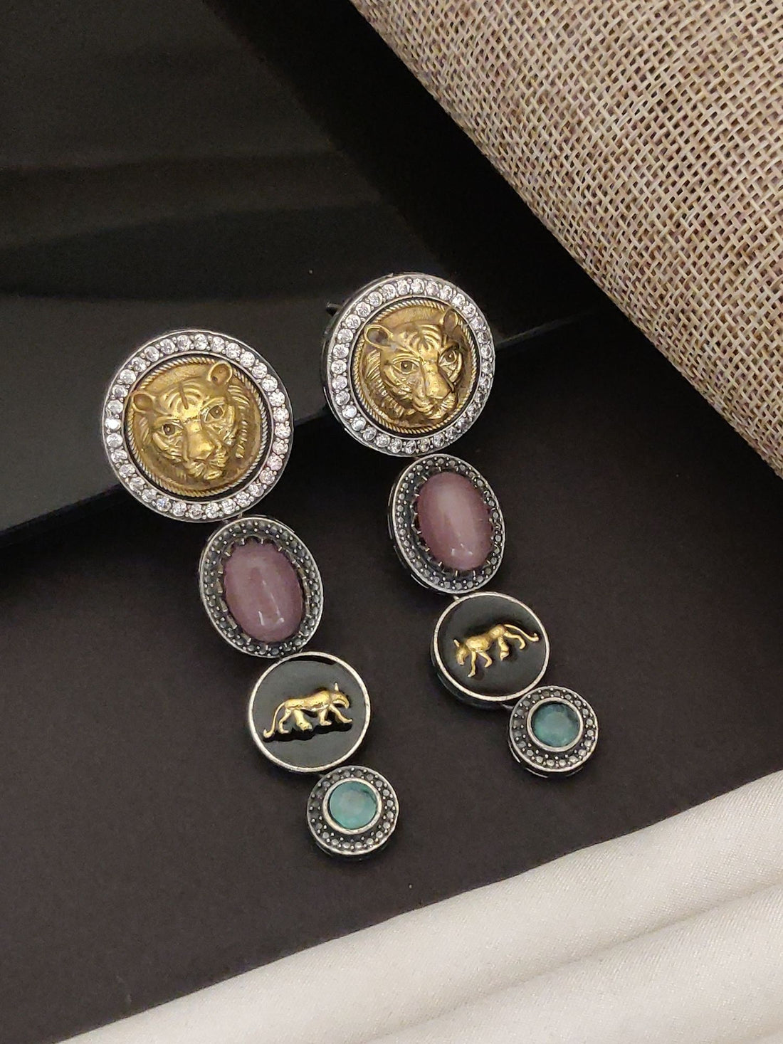 Model wearing long Sabyasachi inspired silver earrings by Abdesignsjewellery featuring gold lion motif red and turquoise stones