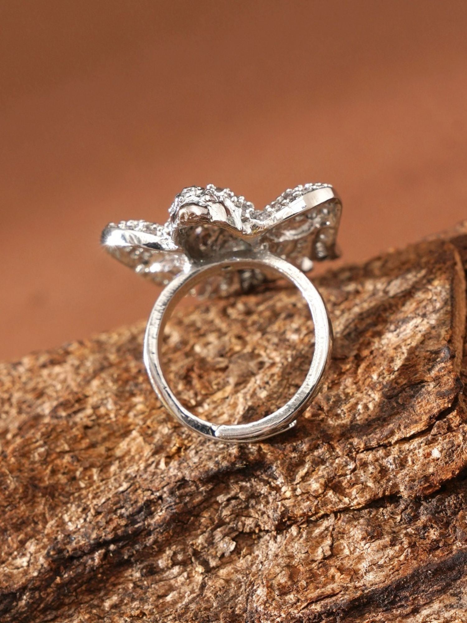 Abdesignsjewellery silver plated American diamond bird ring shown from back on textured wood background