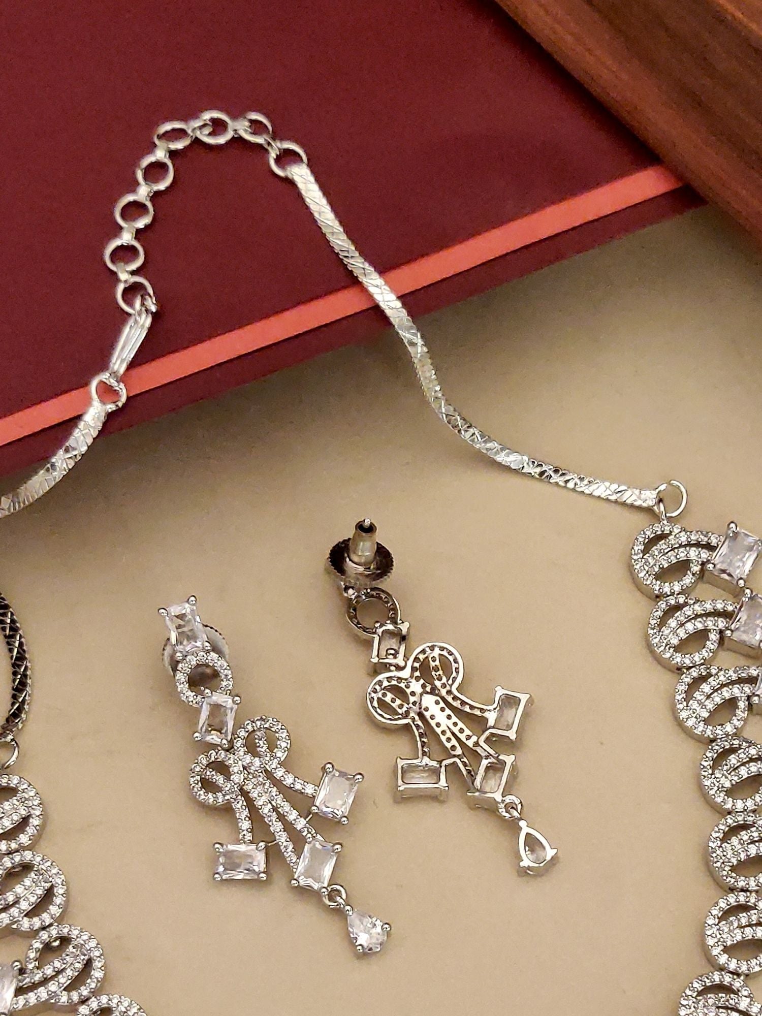 Abdesignsjewellery silver plated american diamond necklace set with intricate pendant and matching drop earrings beige backdrop