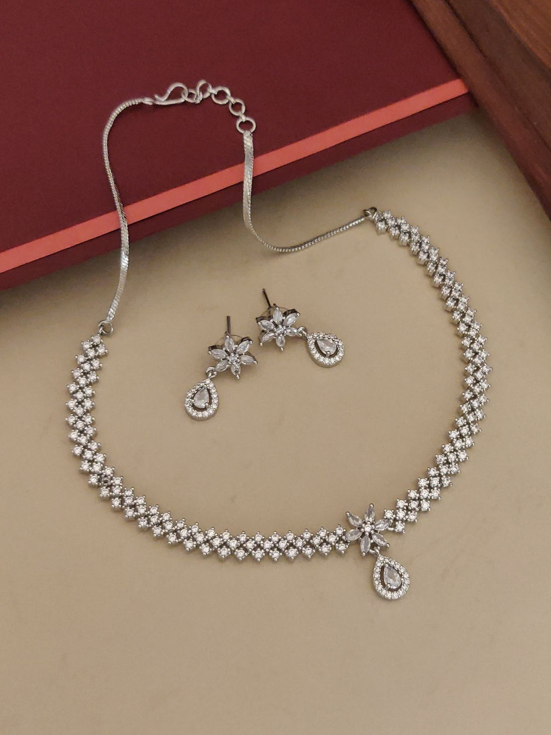 Abdesignsjewellery silver plated American diamond necklace set with floral drop earrings on beige background