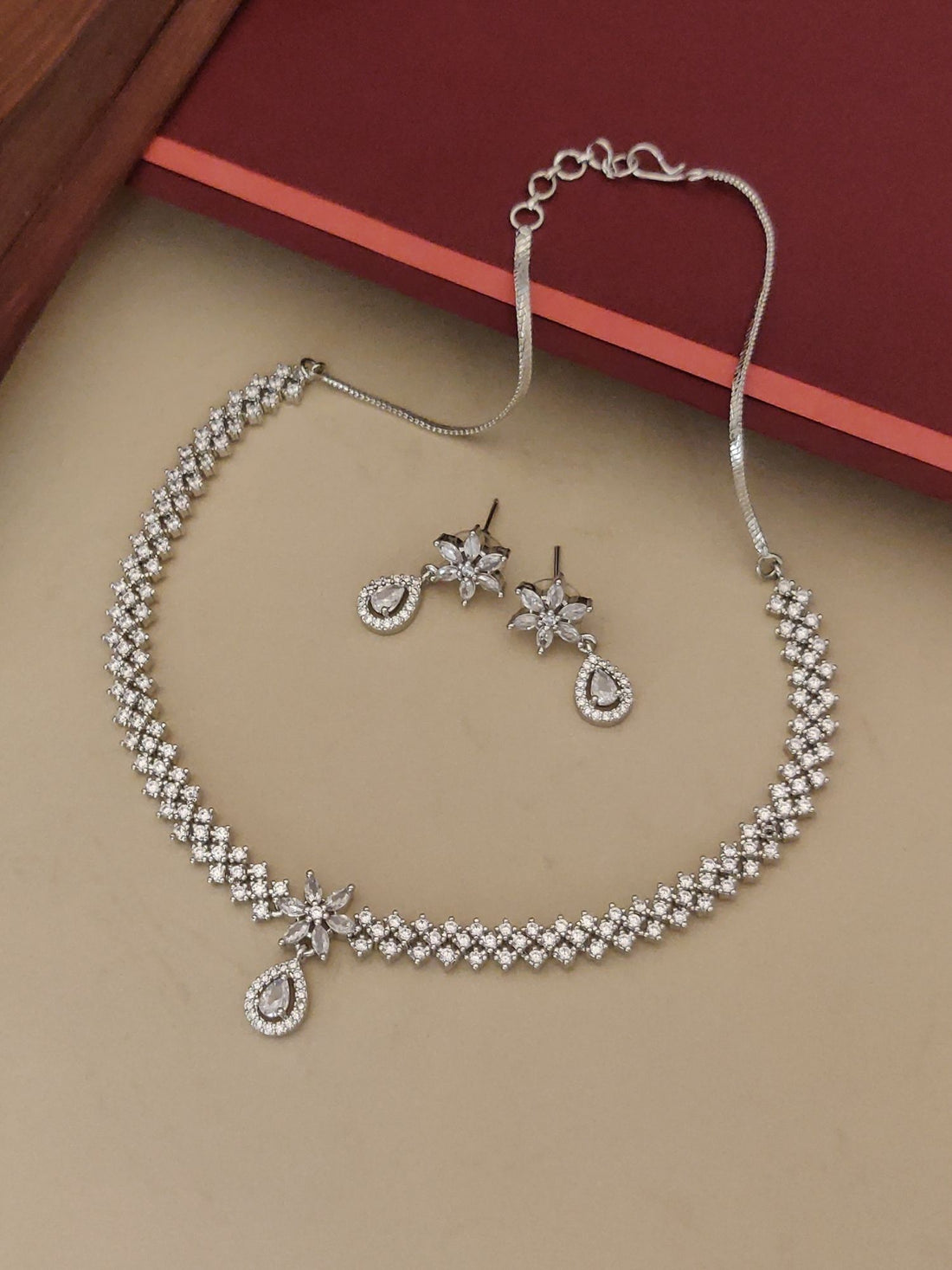 Abdesignsjewellery silver plated American diamond necklace set with floral drop earrings on beige background