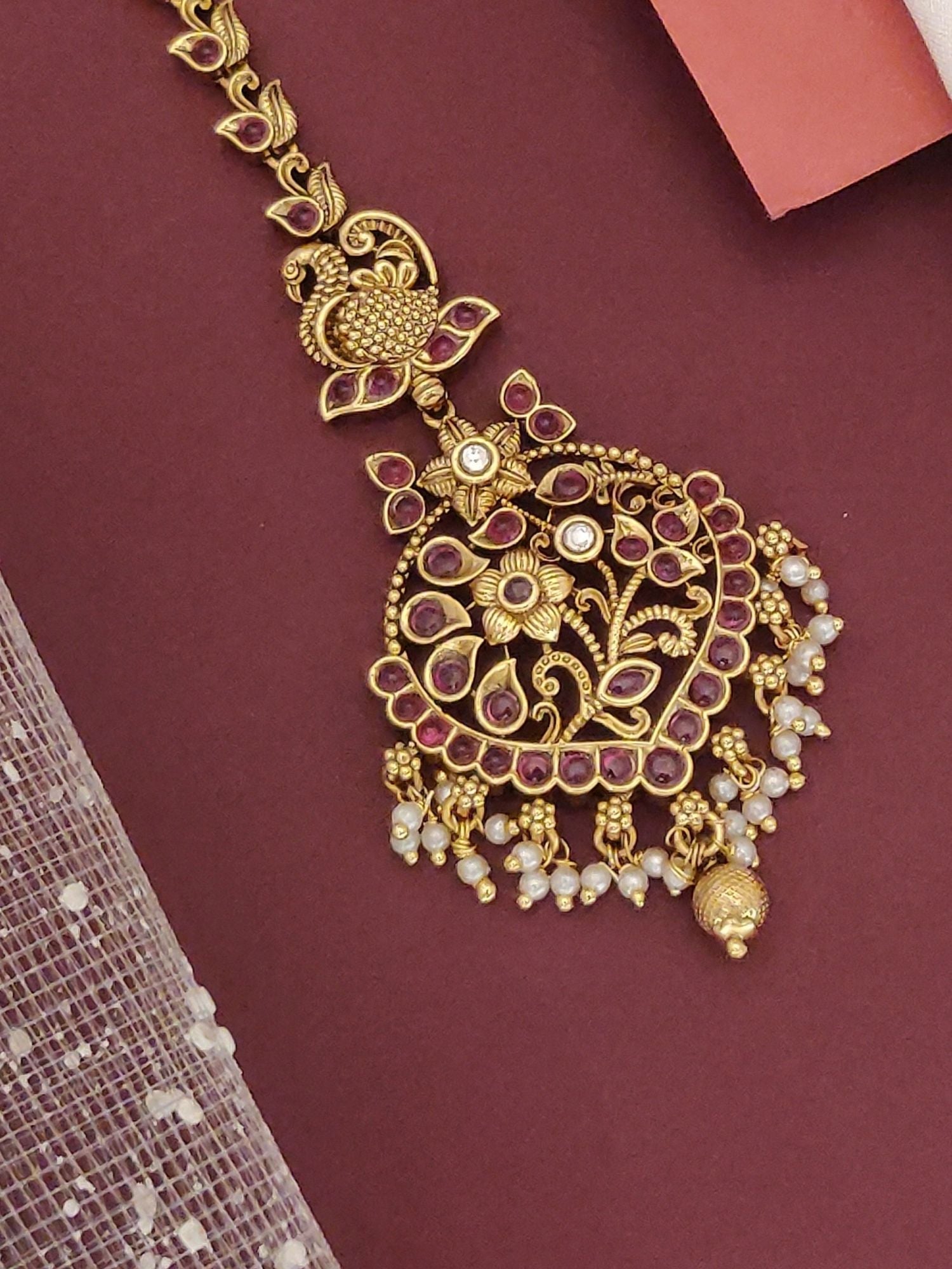 South Indian gold plated maangtikka from Abdesignsjewellery with maroon stones floral motif and pearl danglers for bridal wear