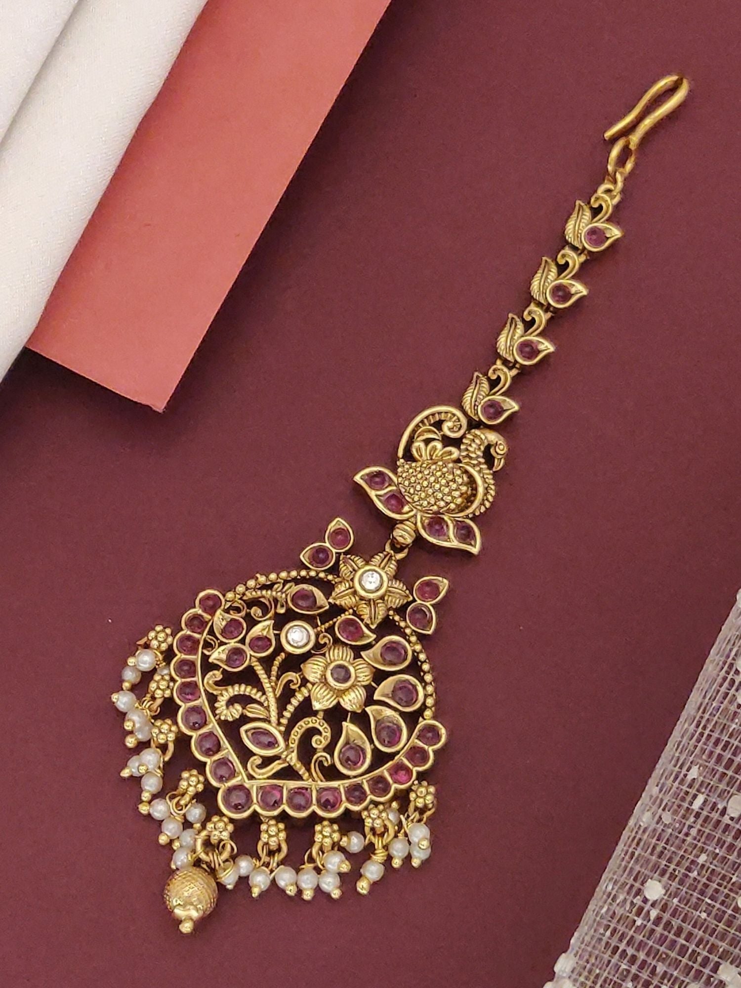 South Indian gold plated maangtikka with intricate floral filigree pink stones and pearl dangles for bridal wear