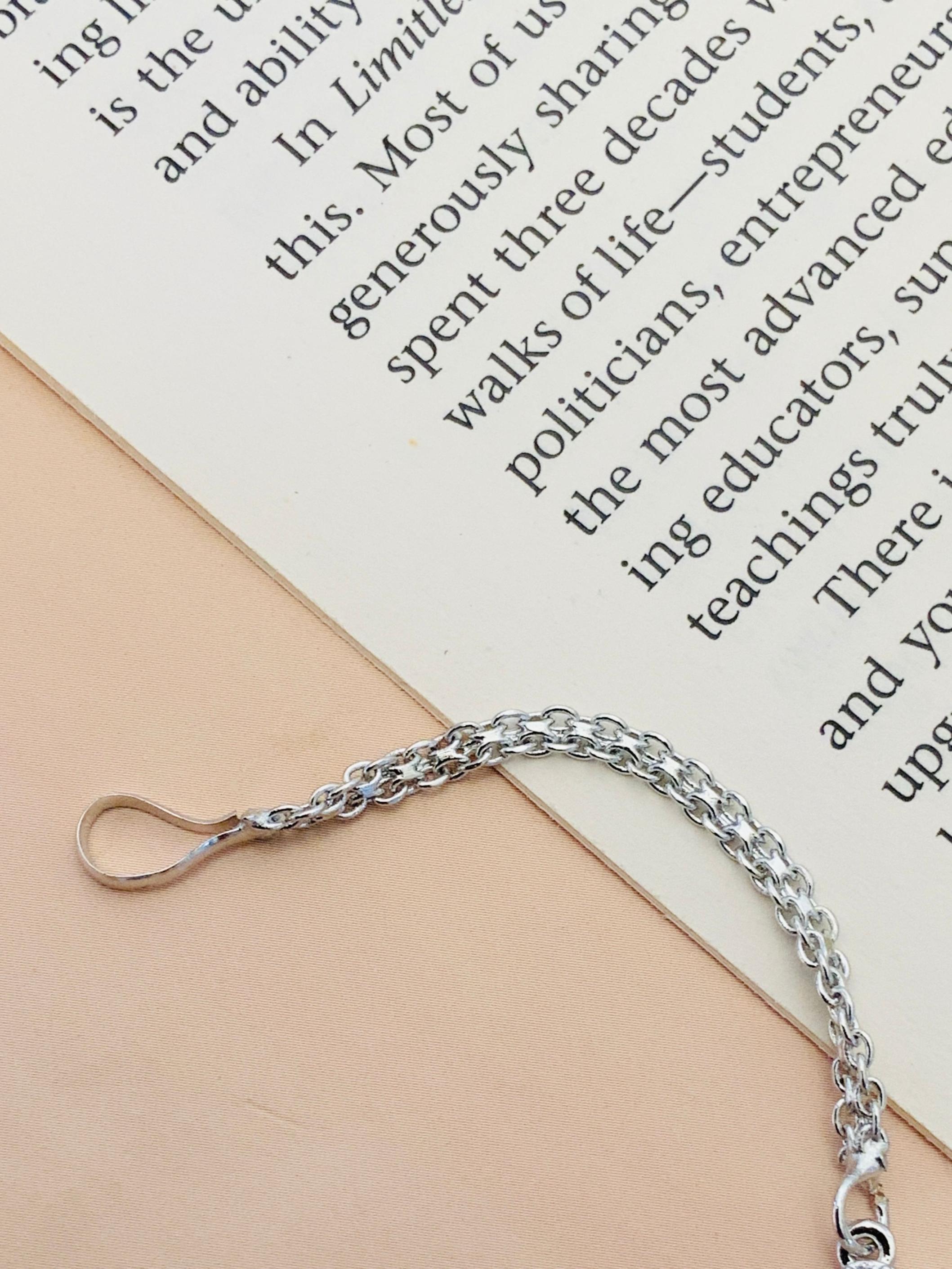 Close-up of Timeless Silver Plated American Diamond Maangtikka chain by Abdesignsjewellery on beige and white background