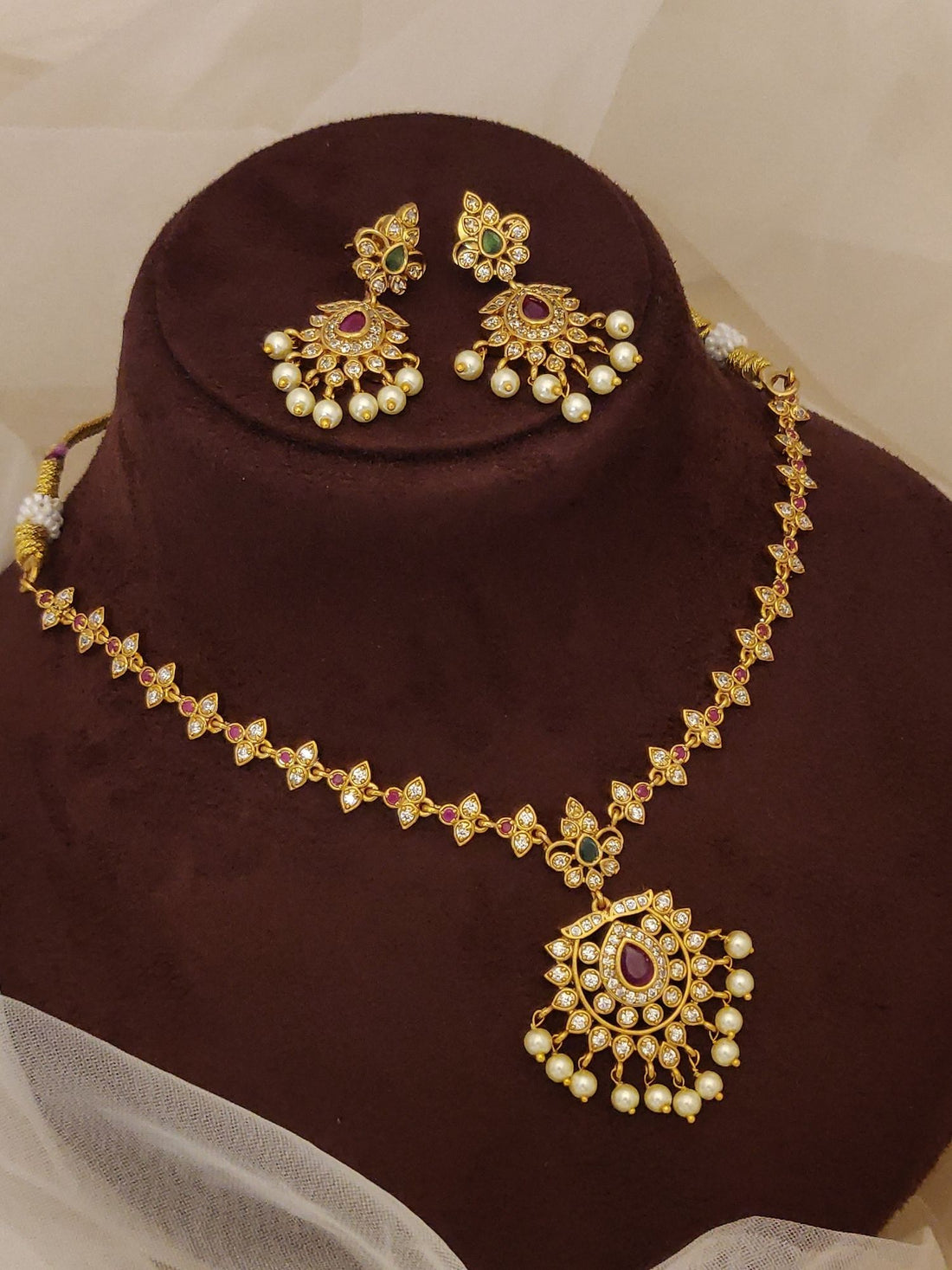 Traditional South Indian gold plated necklace set by Abdesignsjewellery with red stone pendant pearls and matching earrings